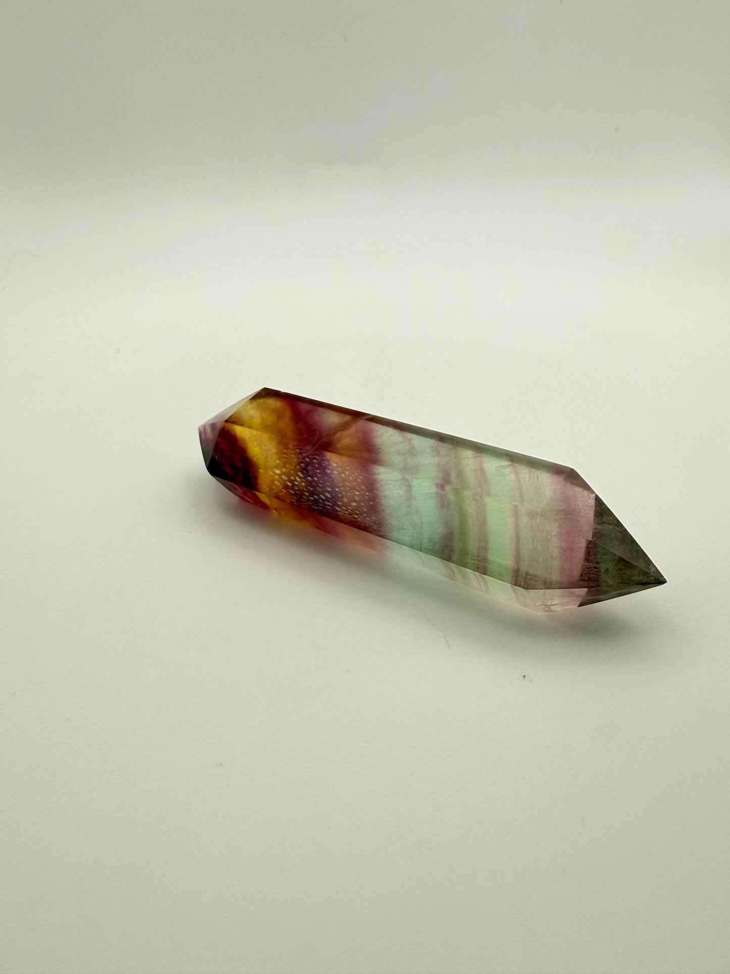 Rainbow Fluorite polished crystal in the shape of a double term.