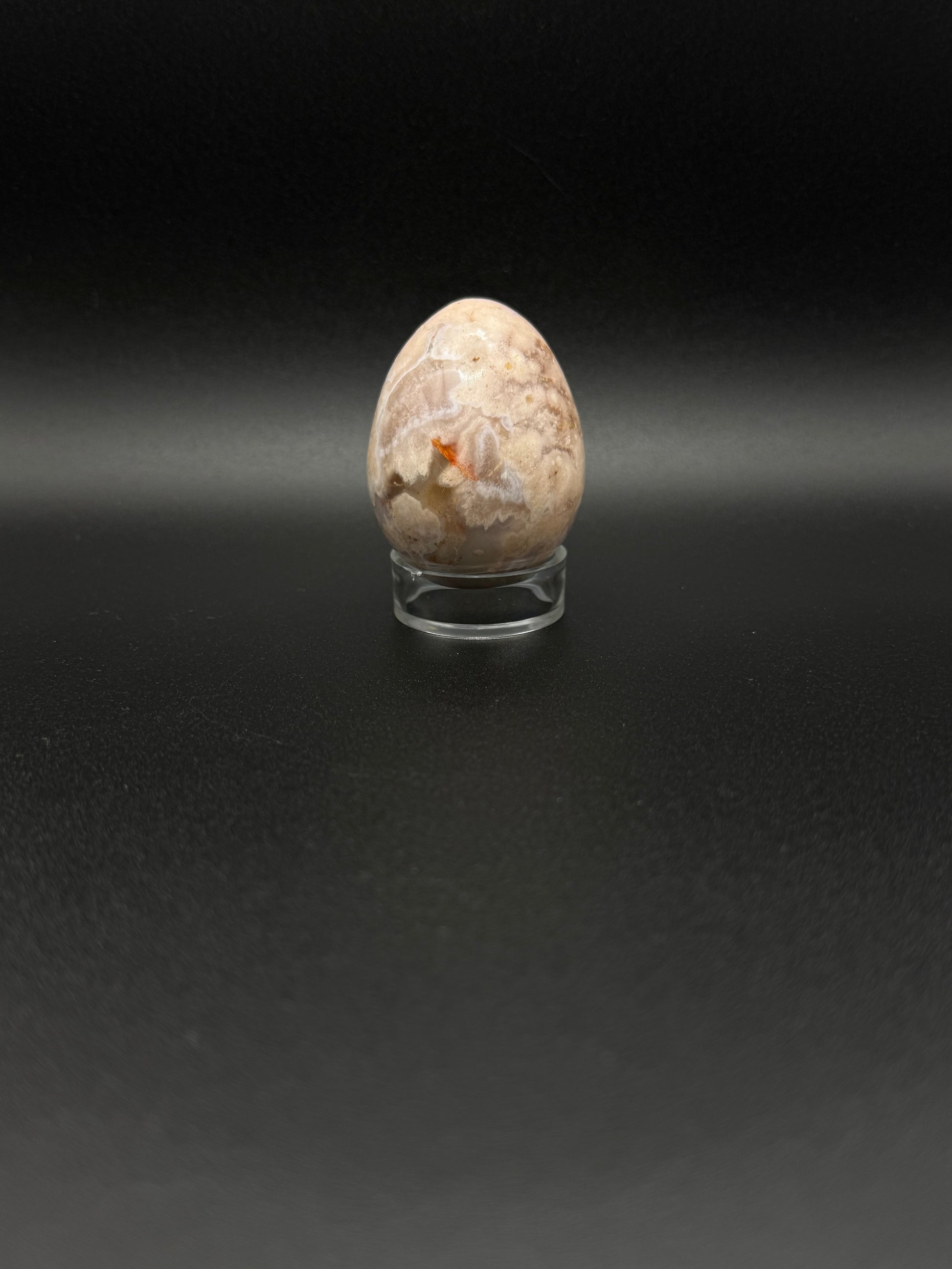 Polished flower agate crystal in the shape of an egg.