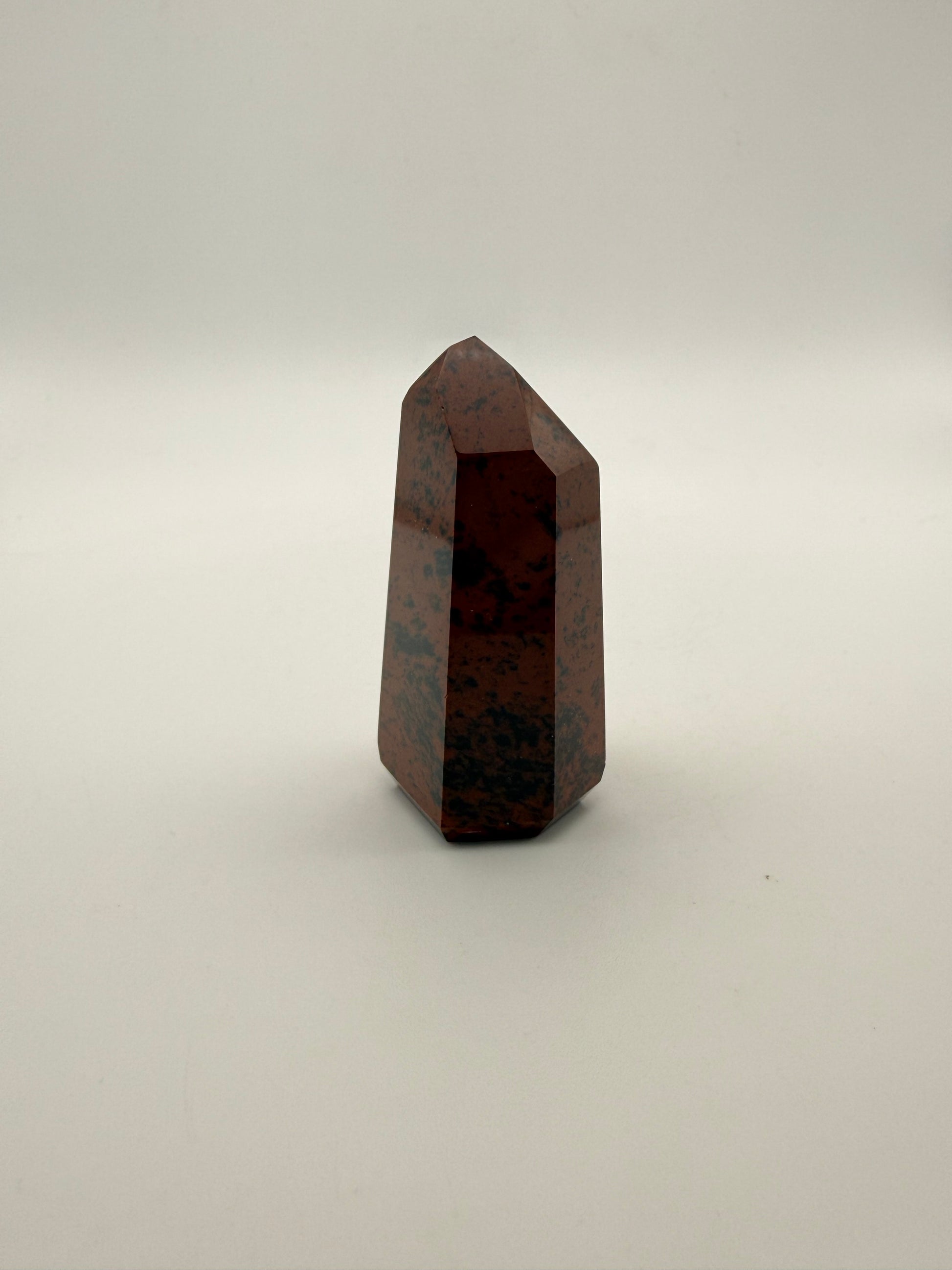 Polished mahogany obsidian tower with six sides.