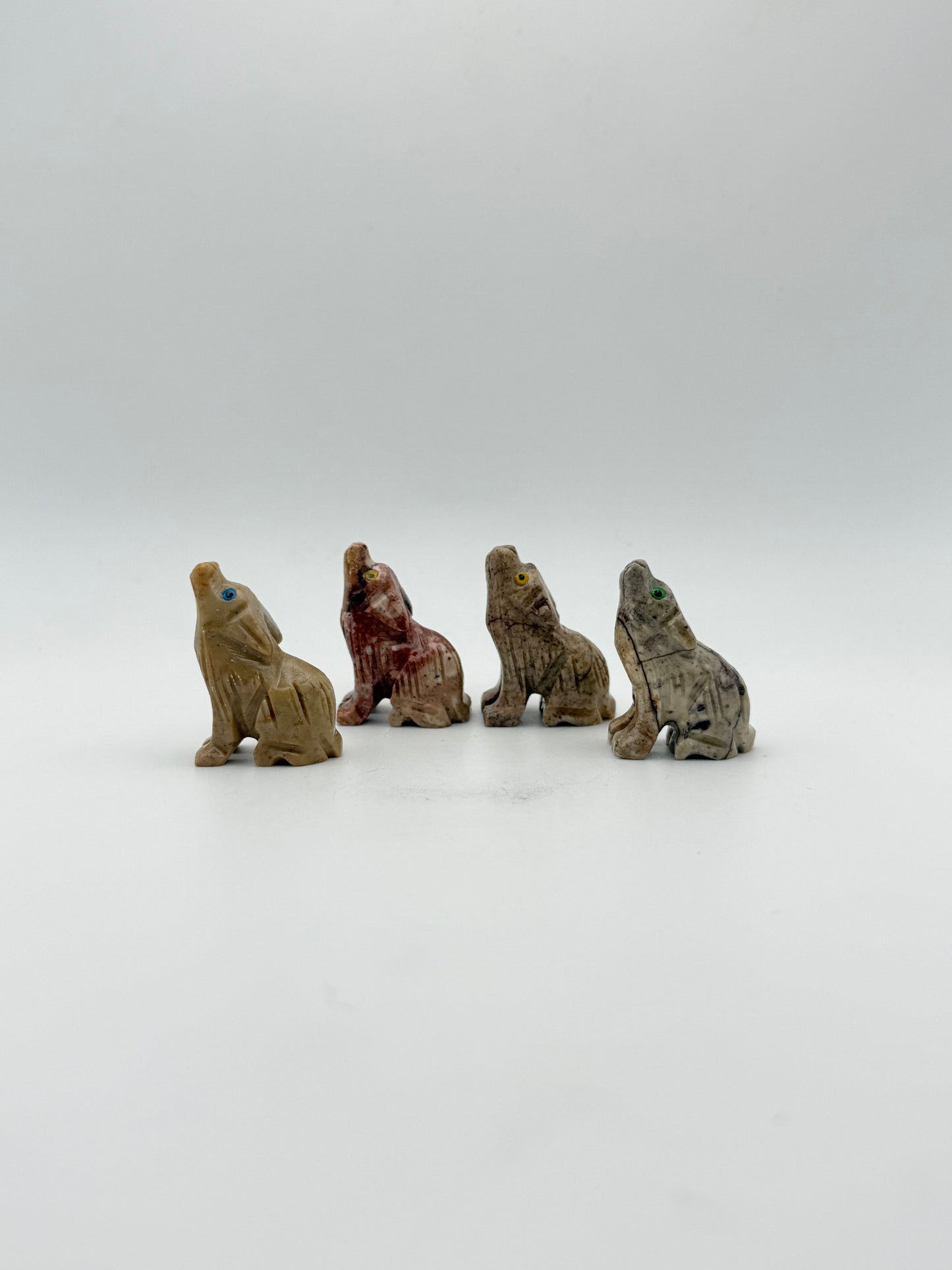Small stone sculptures of animals arranged vertically on a white background