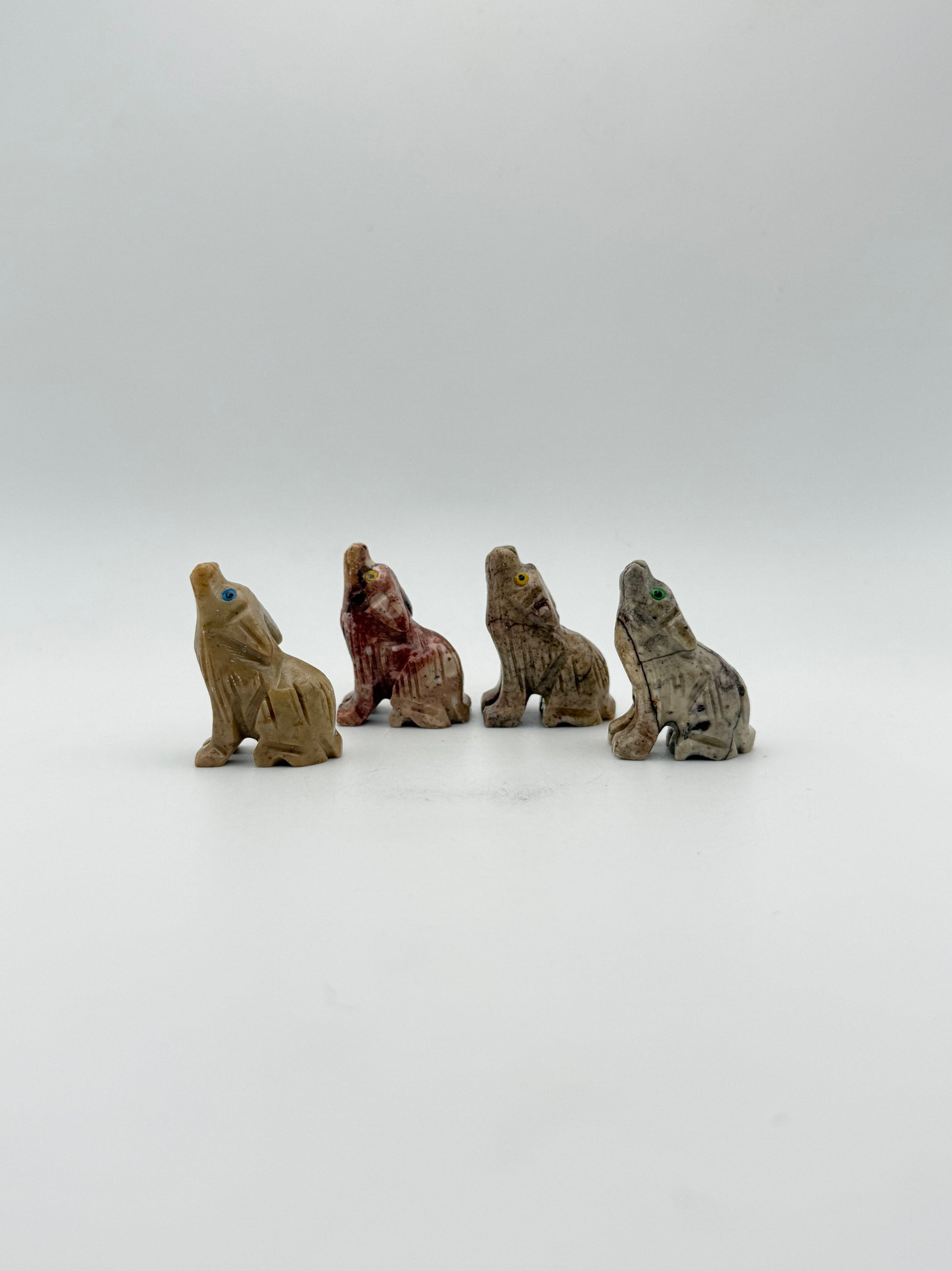 Small stone sculptures of animals arranged vertically on a white background