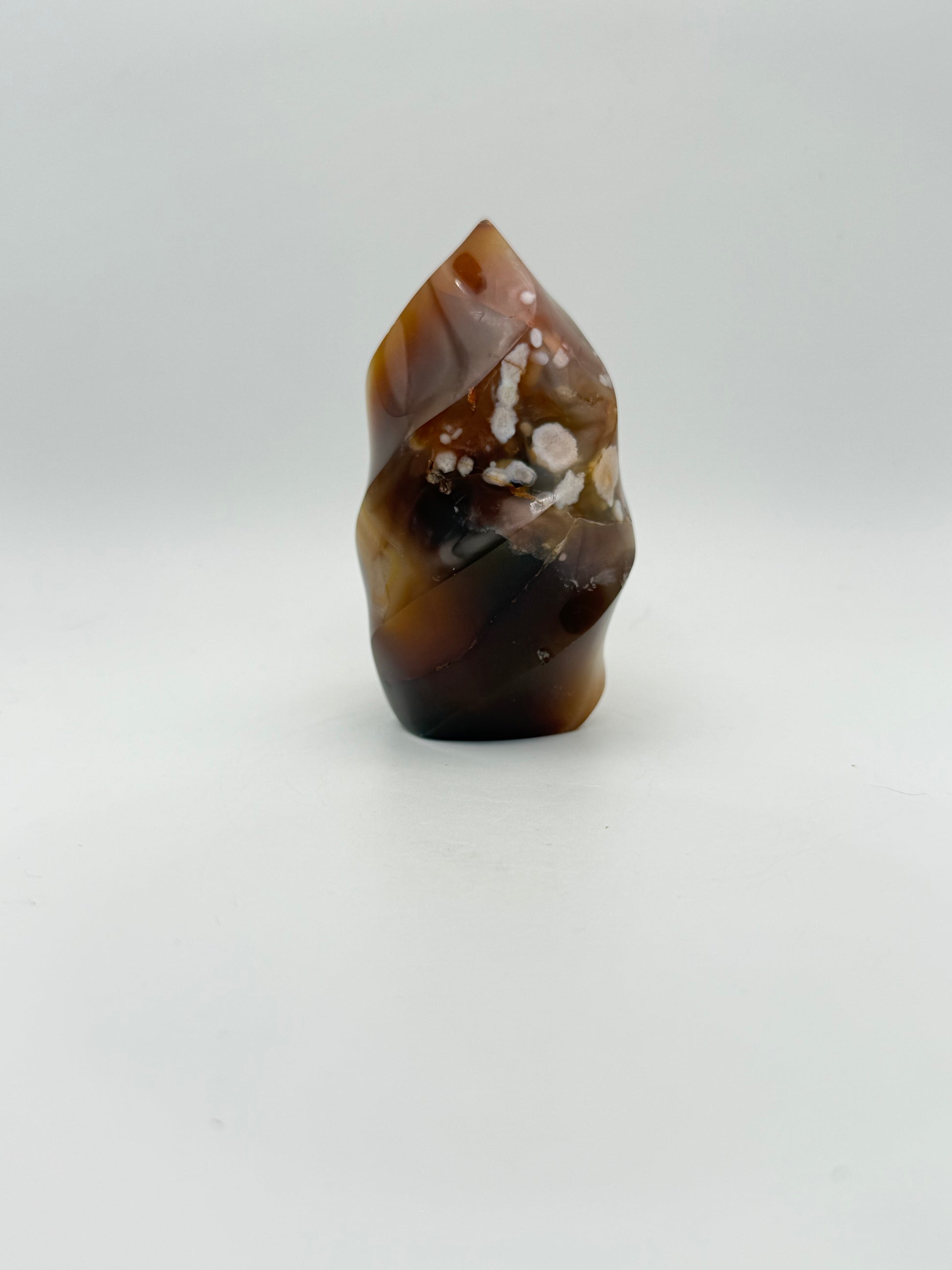 A polished carnelian stone with a flame shape, featuring an orange to red gradient color.