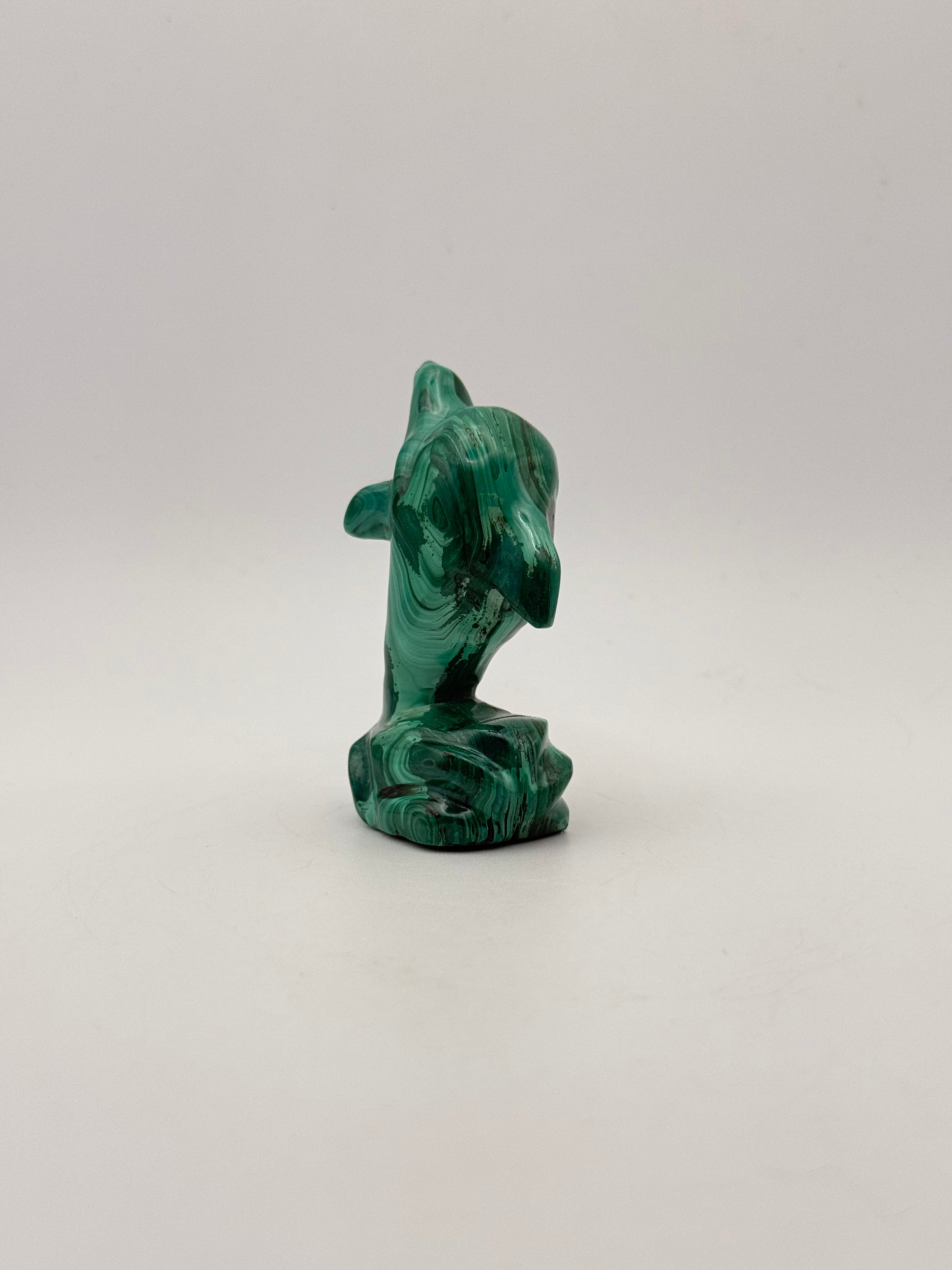 Polished malachite dolphin carving.