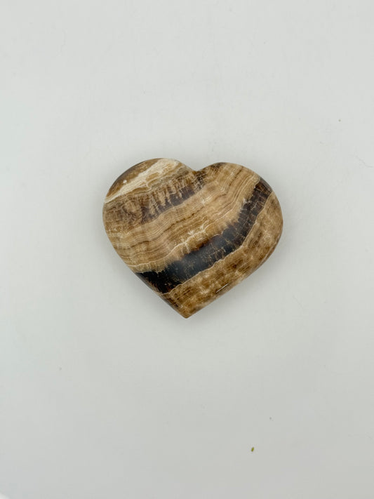 A polished chocolate calcite heart-shaped stone with a brown and white marbled pattern.