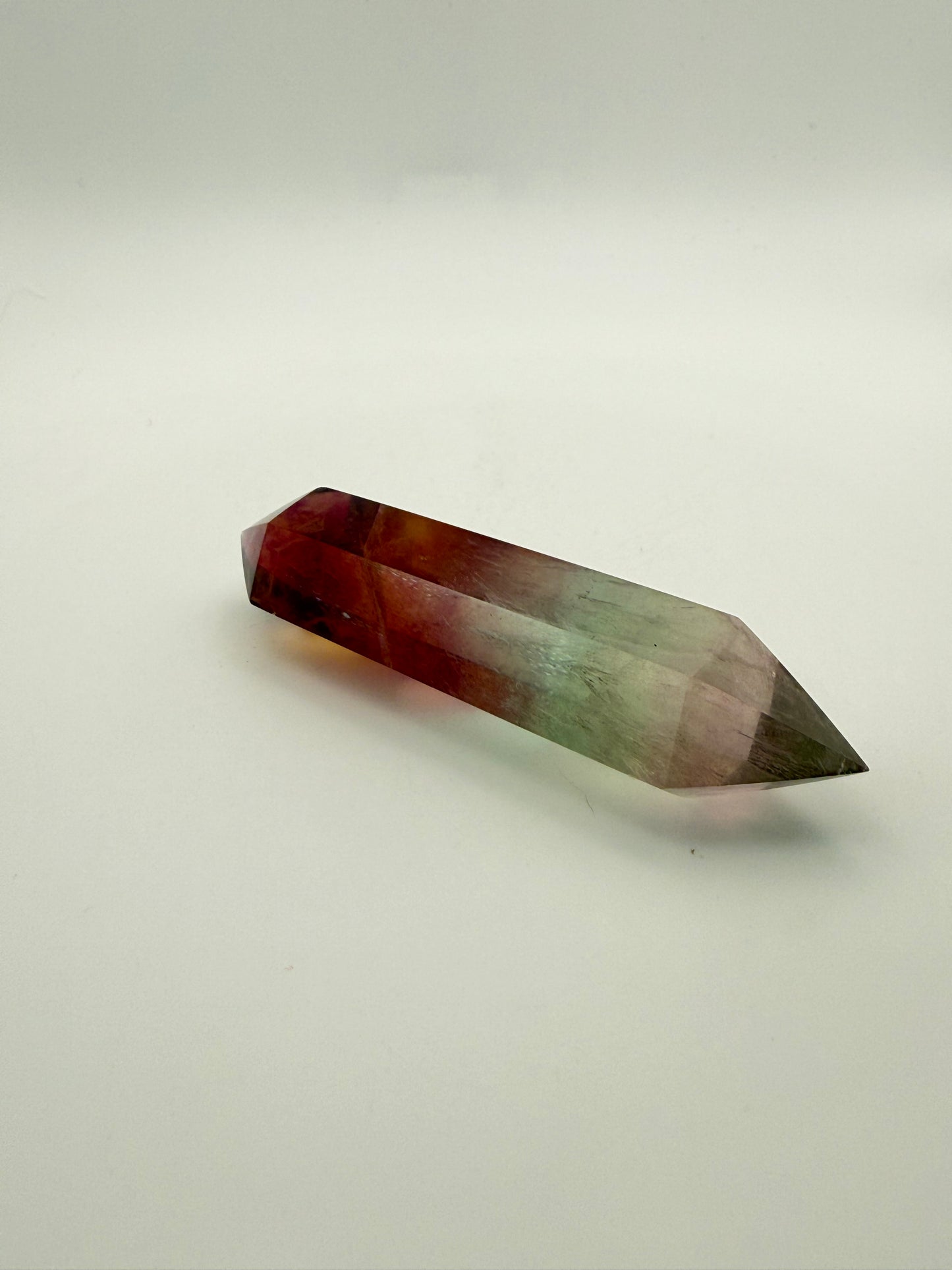 Rainbow Fluorite polished crystal in the shape of a double term.