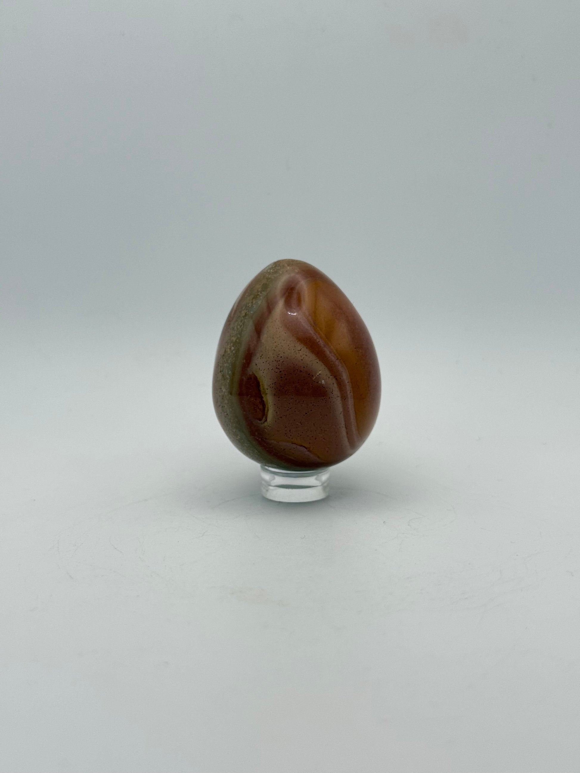 Polished polychrome jasper shaped into an egg.