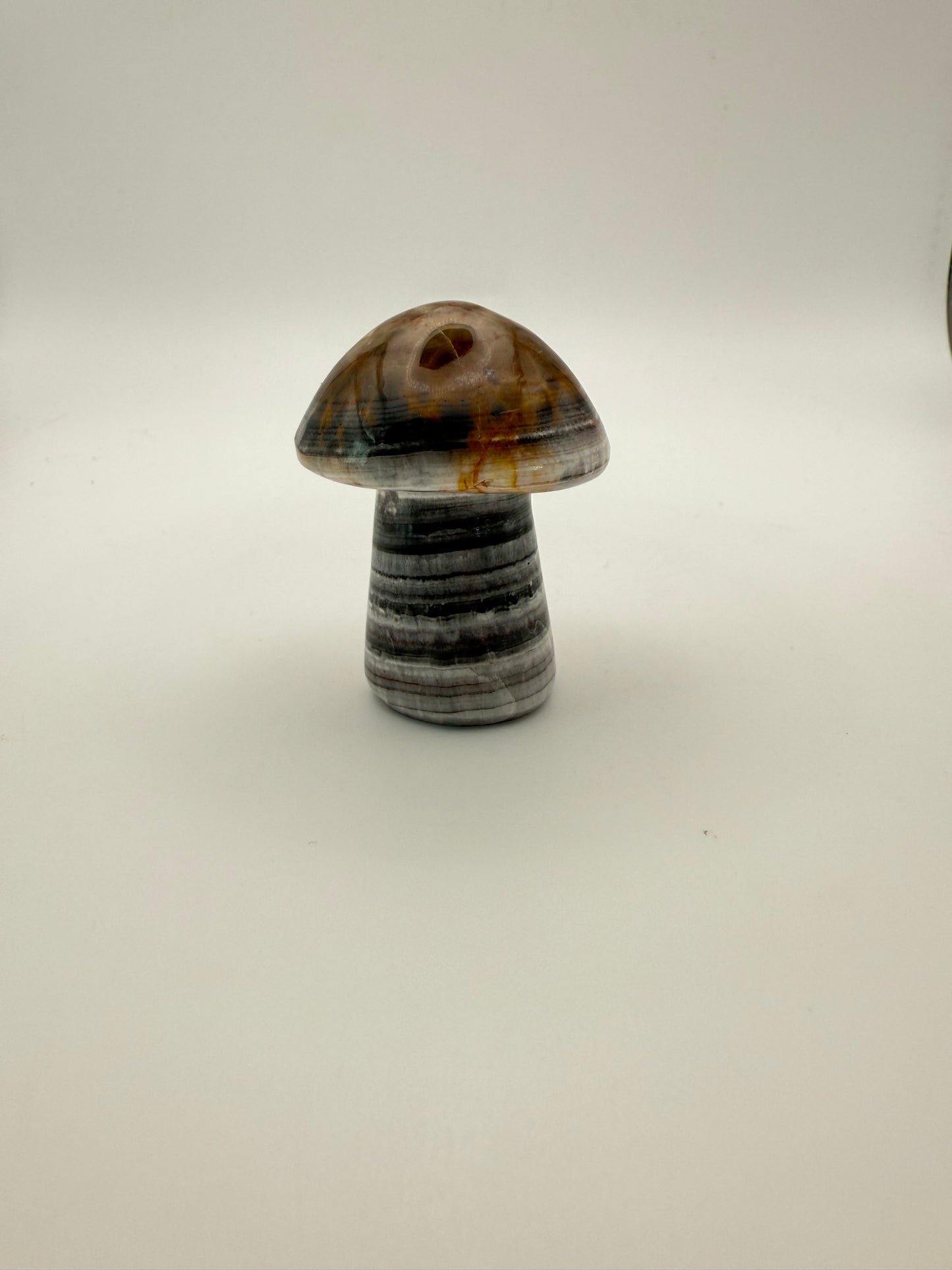 Polished chocolate calcite crystal shaped into a mushroom.