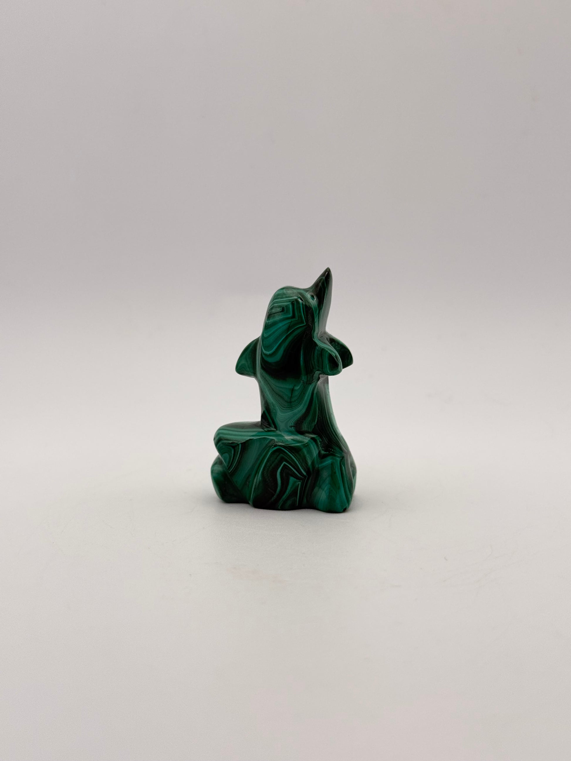 Polished malachite dolphin carving.