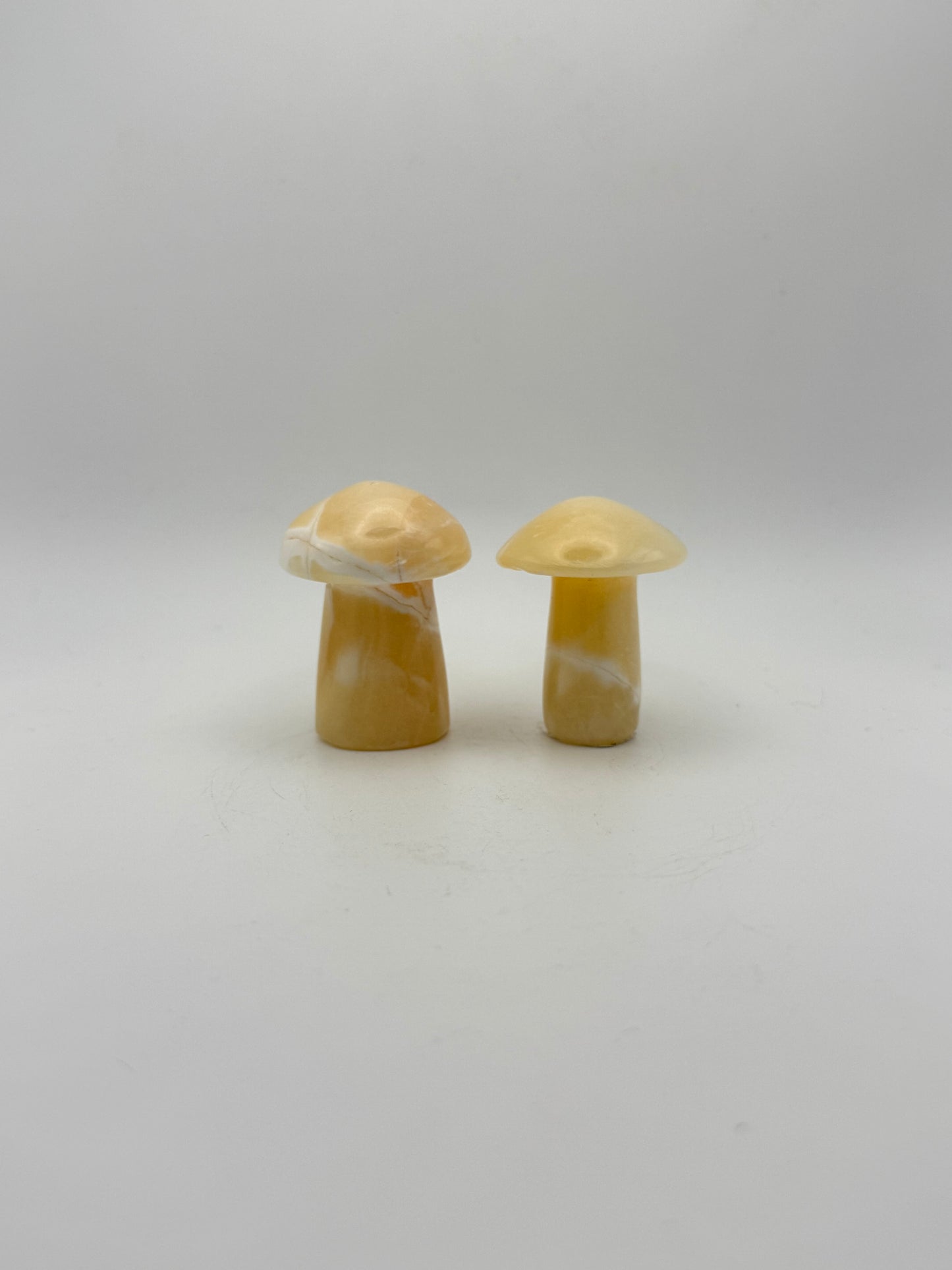 Two orange calcite mushrooms.