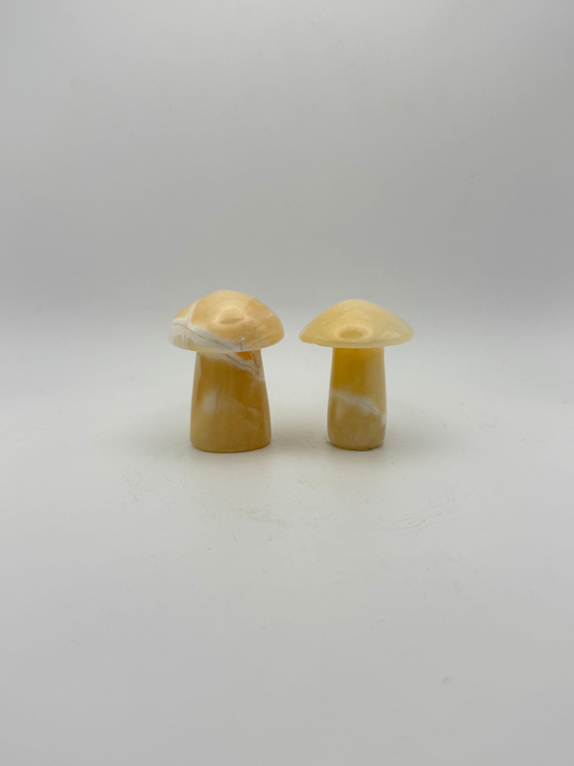 Two orange calcite mushrooms.