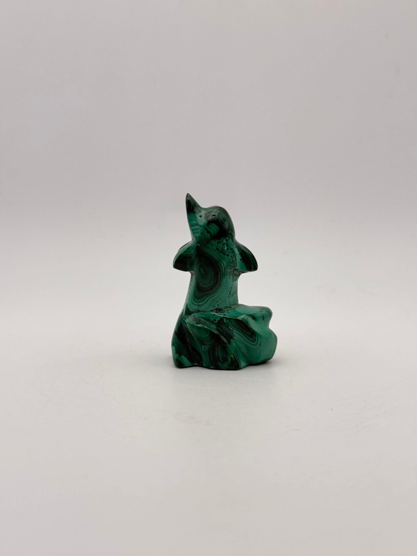 Polished malachite dolphin carving.