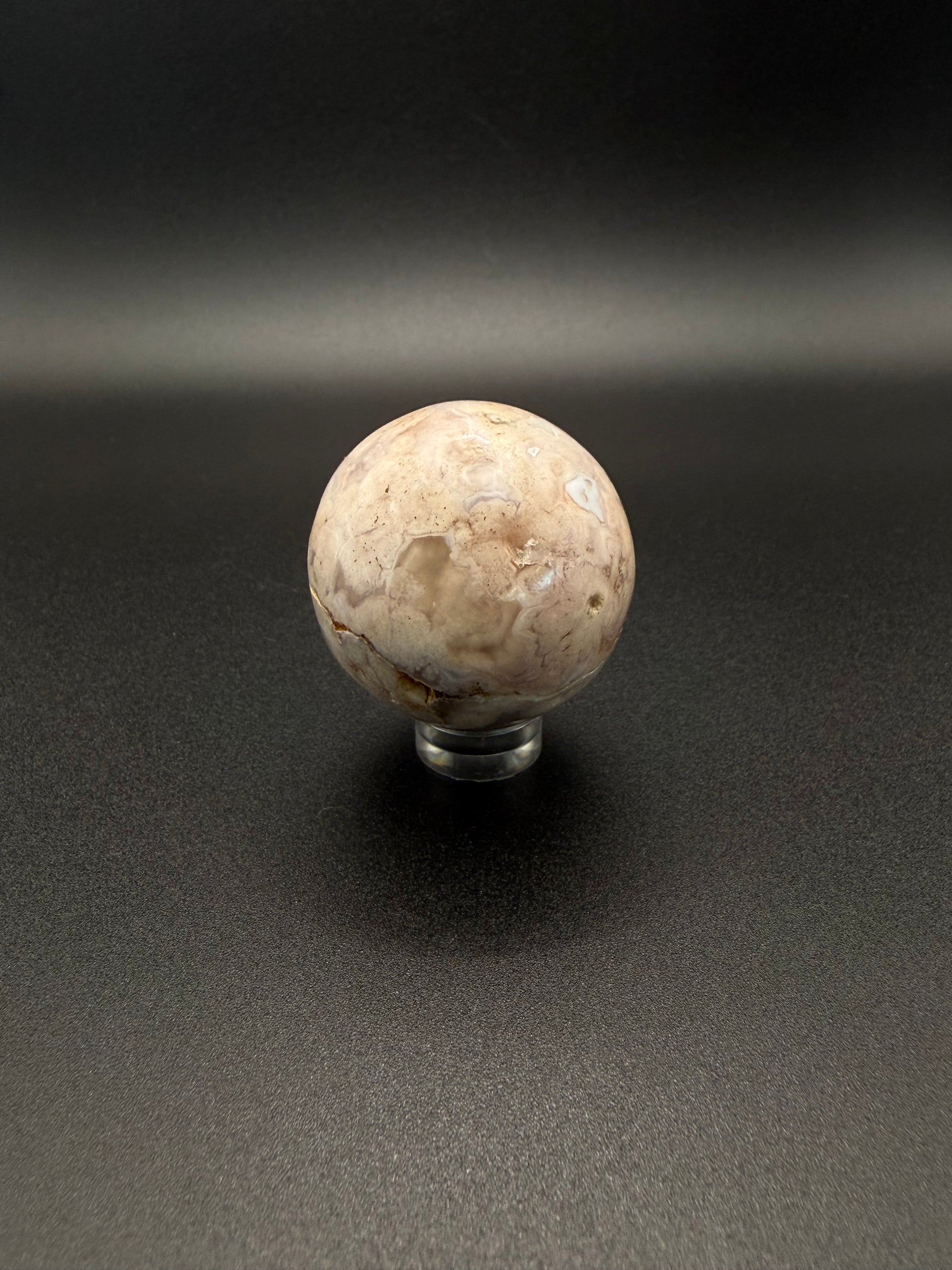 Flower agate polished crystal in the shape of a sphere.