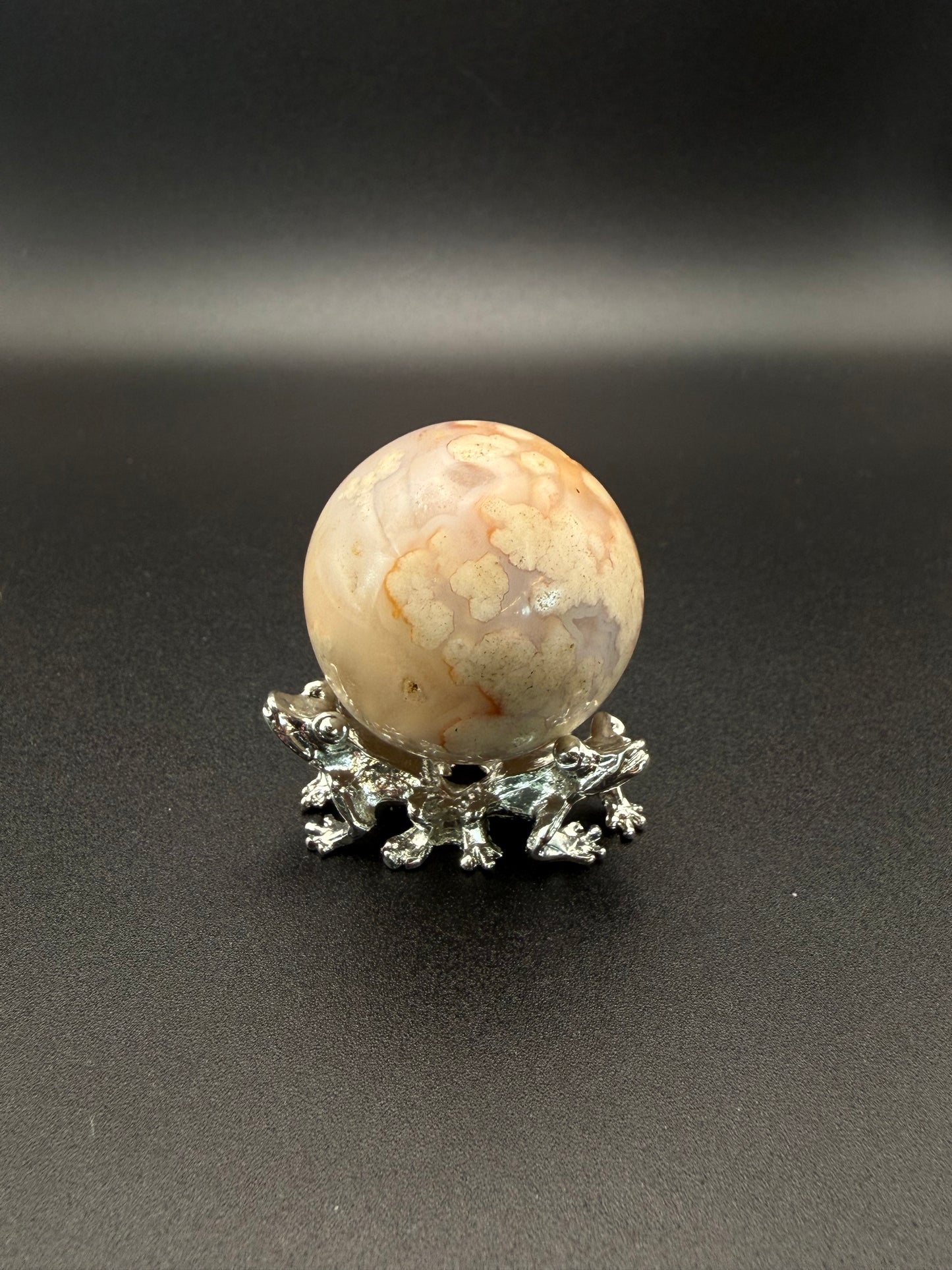Flower agate polished crystal in the shape of a sphere.