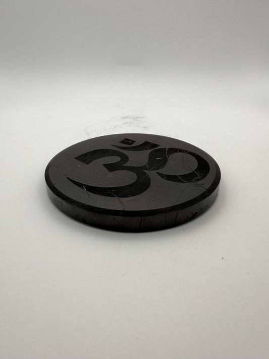 Shungite coaster with OM symbol engraved on it.