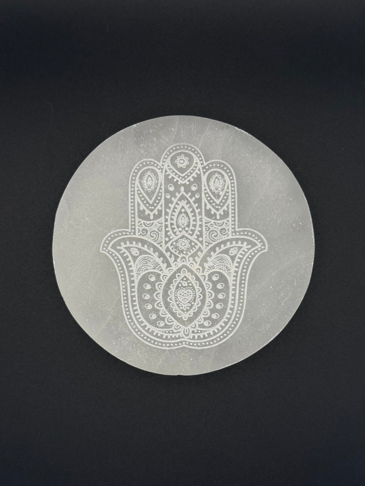 Selenite coaster with engraved hasma hand symbol.