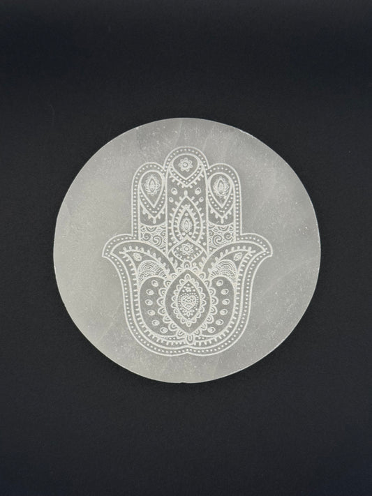 Selenite coaster with engraved hasma hand symbol.