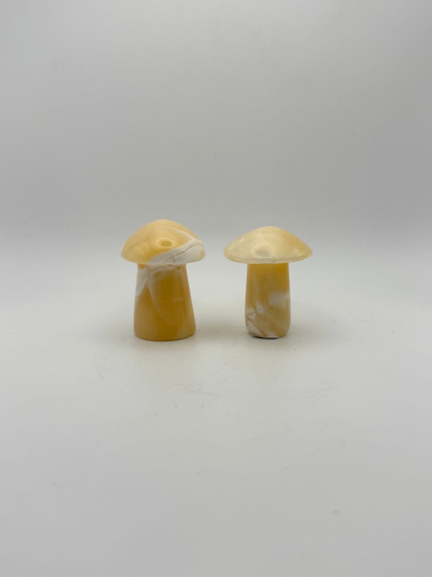 Two orange calcite mushrooms.