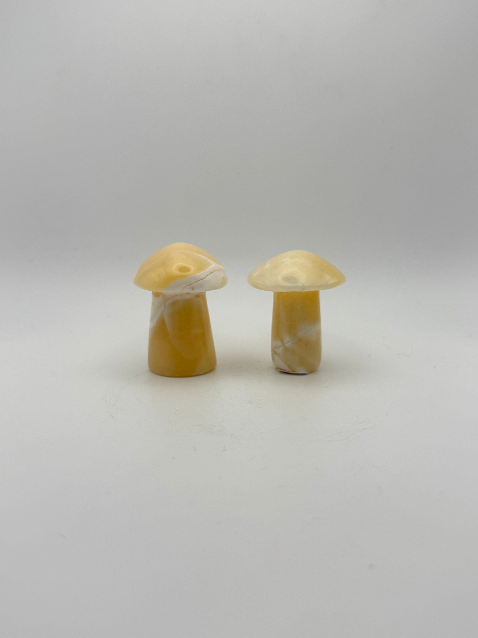 Two orange calcite mushrooms.