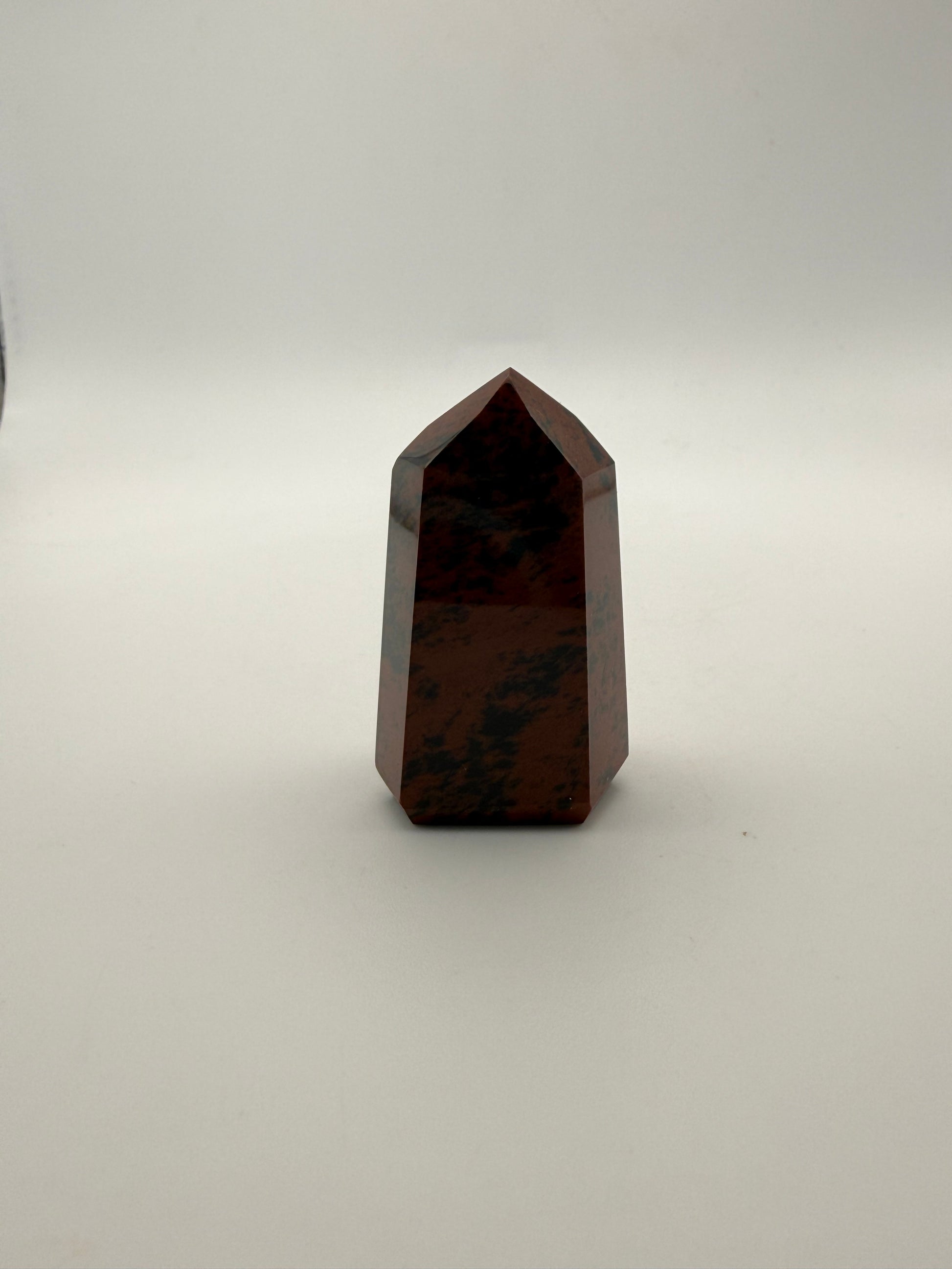 Polished mahogany obsidian tower with six sides.