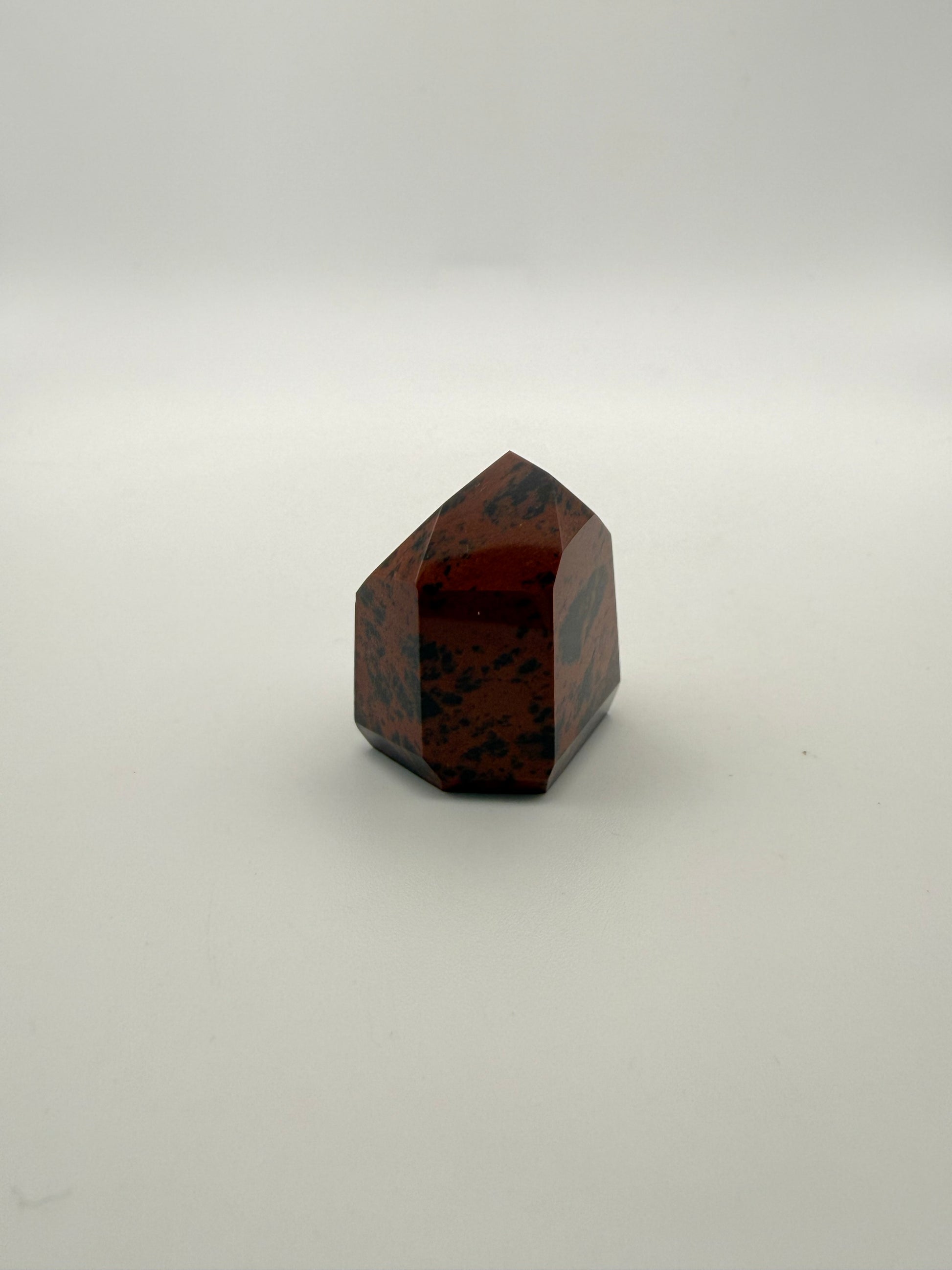 Polished mahogany obsidian tower with six sides.