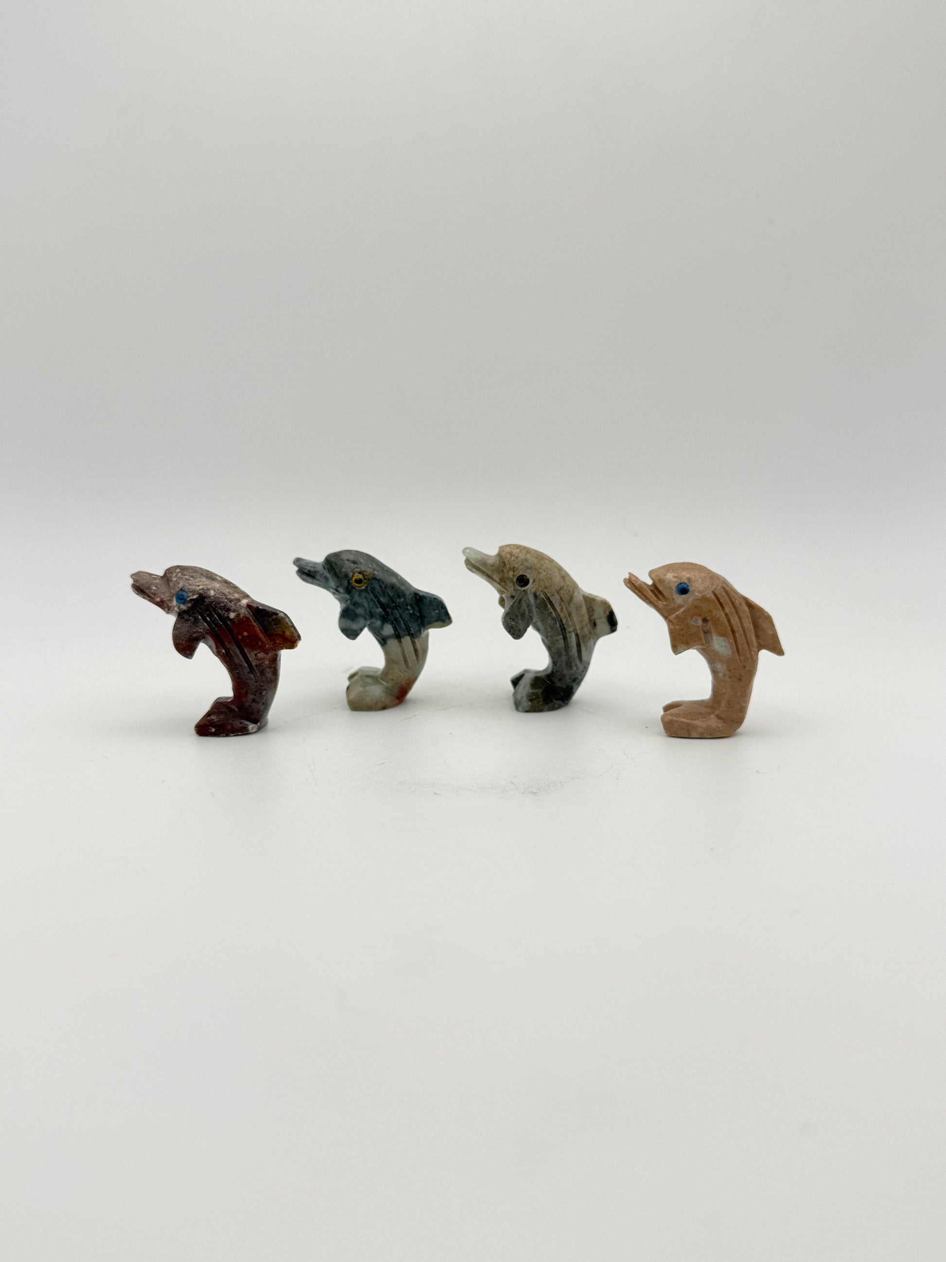 Small stone sculptures of animals arranged vertically on a white background
