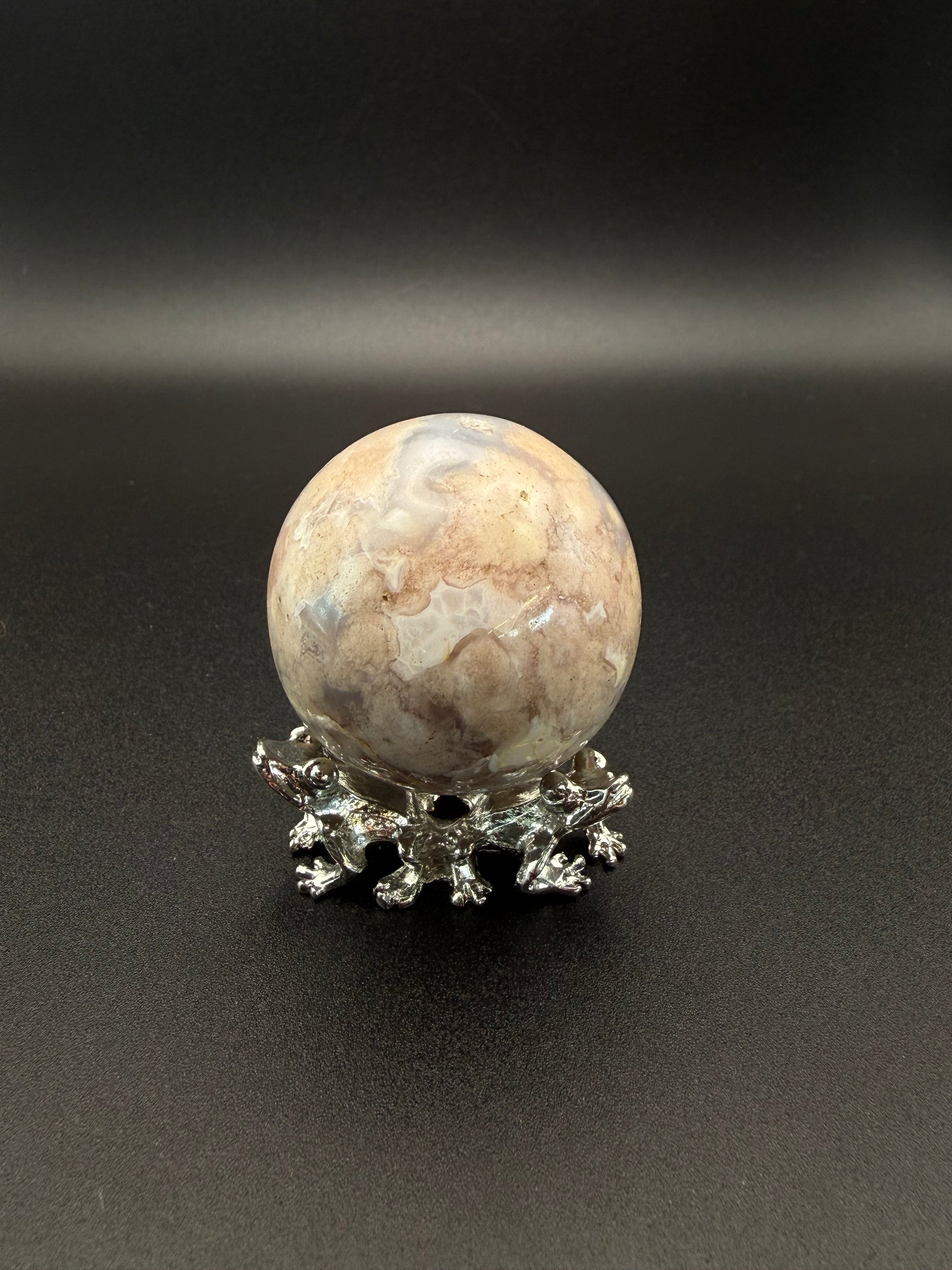Flower agate polished crystal in the shape of a sphere.
