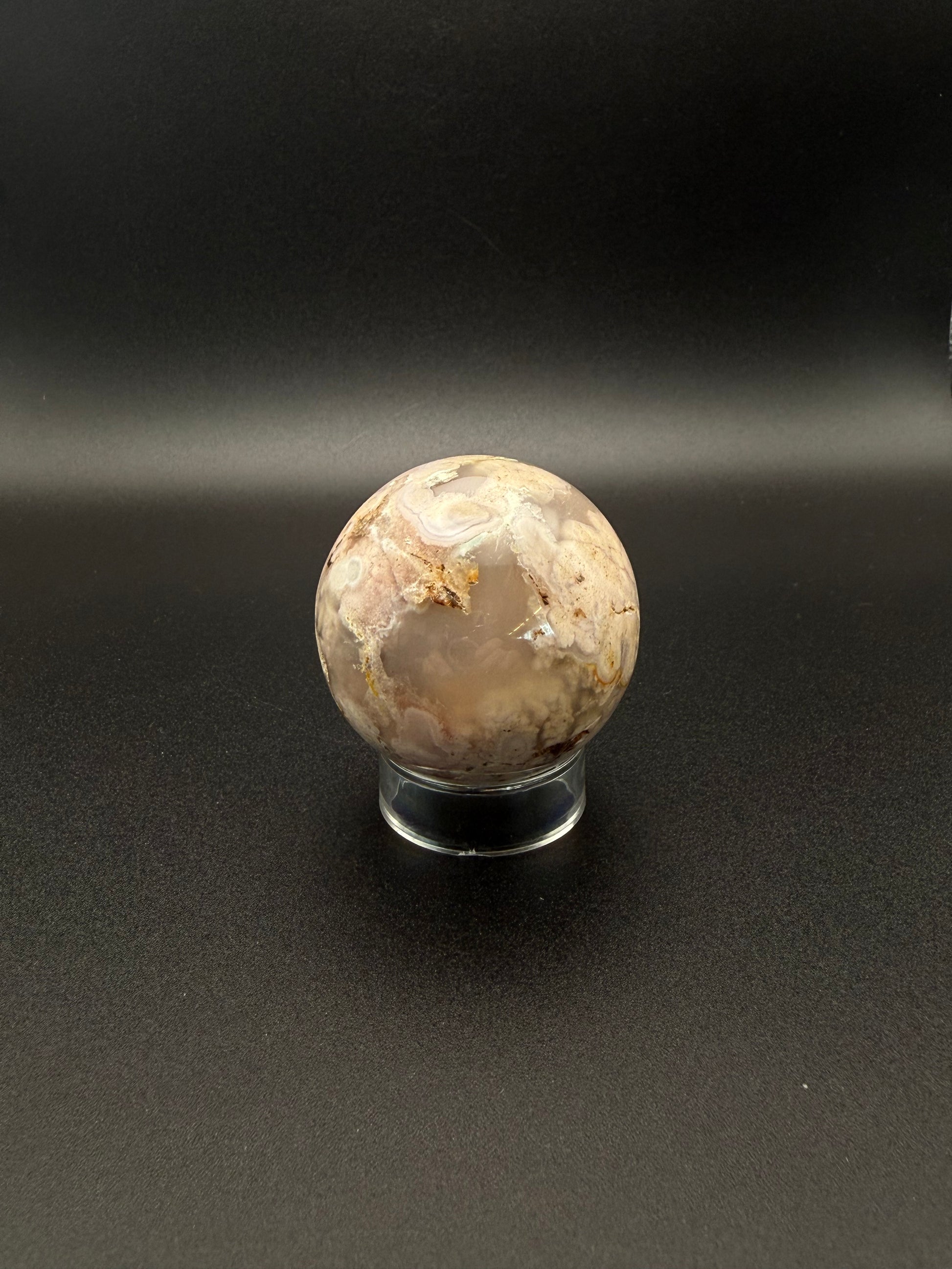 Flower agate polished crystal in the shape of a sphere.