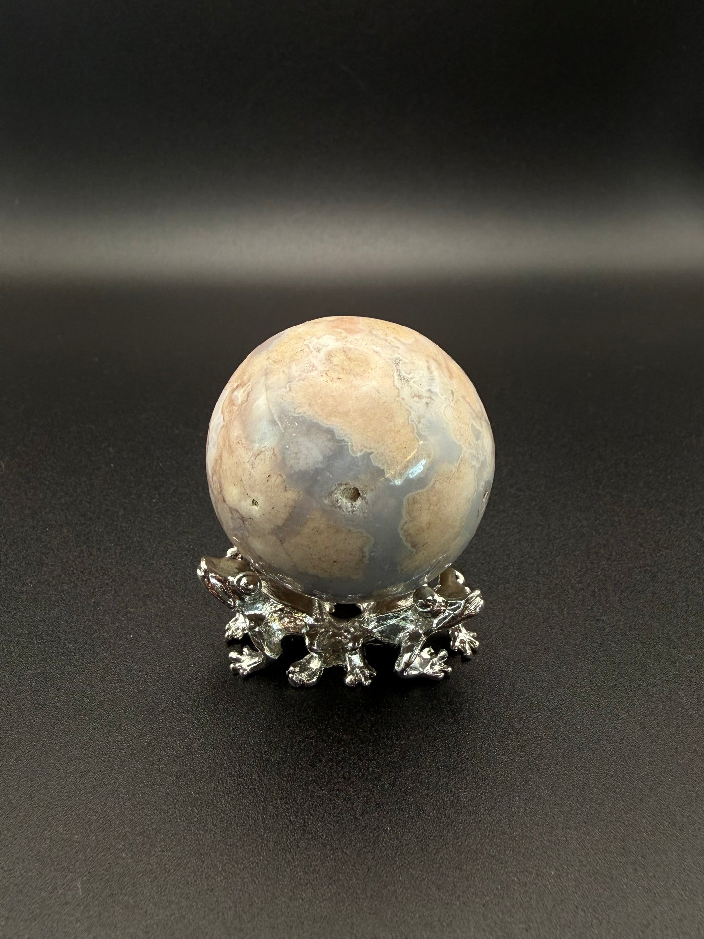 Flower agate polished crystal in the shape of a sphere.