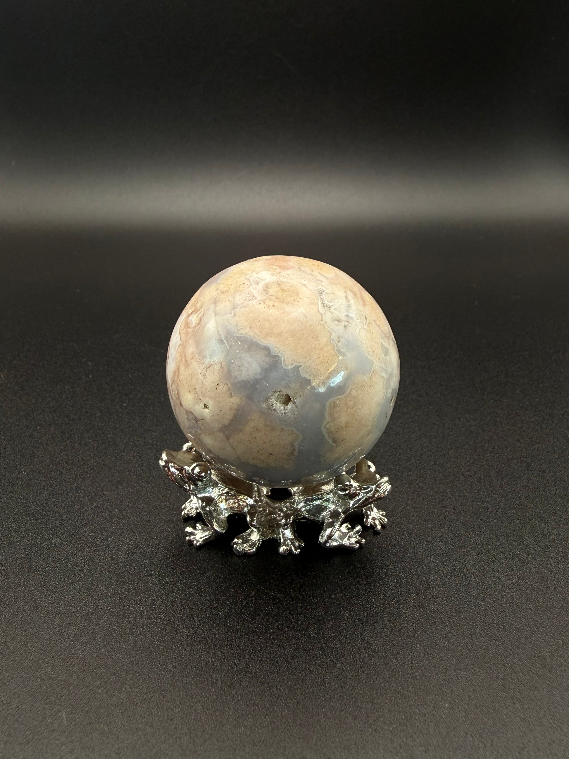 Flower agate polished crystal in the shape of a sphere.