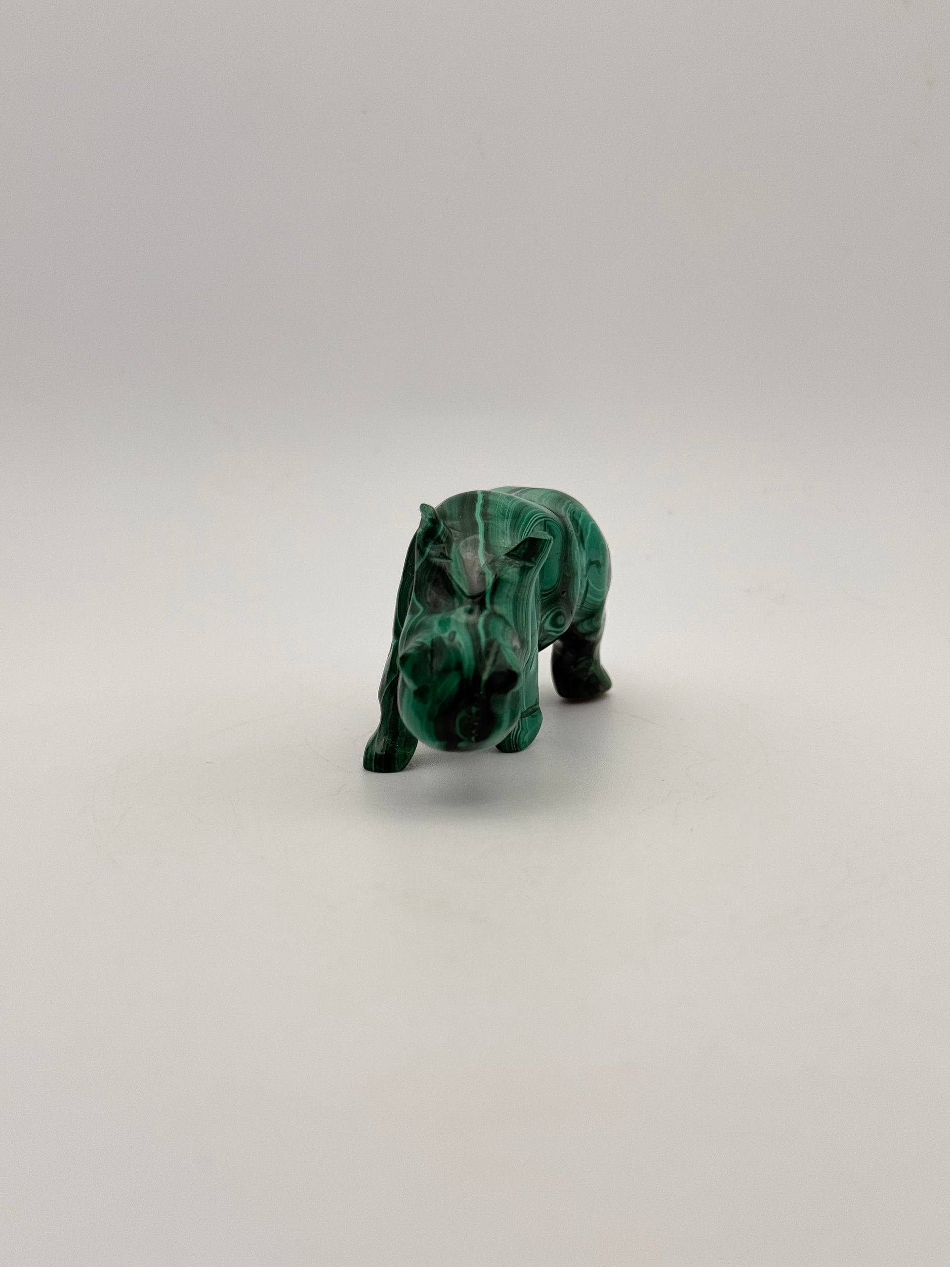 Vibrant green malachite stone carving of a rhino.