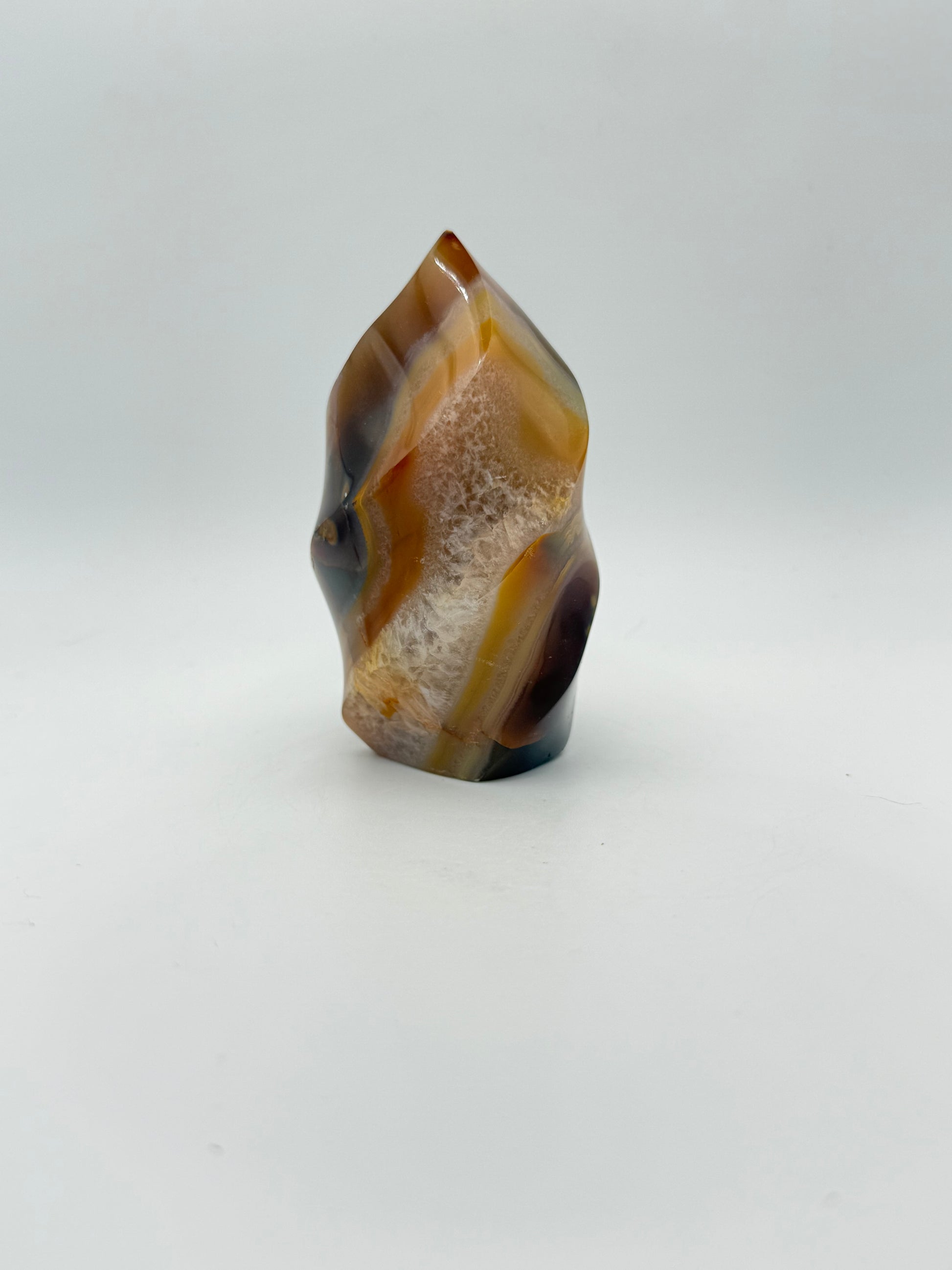 A polished carnelian stone with a flame shape, featuring an orange to red gradient color.