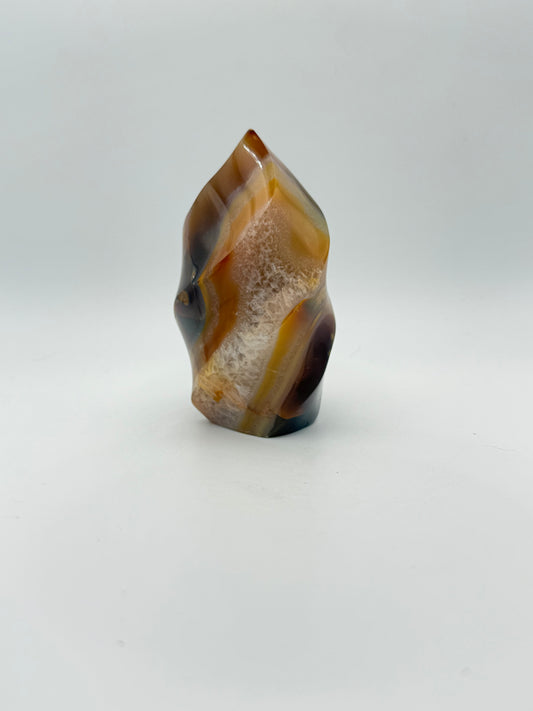A polished carnelian stone with a flame shape, featuring an orange to red gradient color.