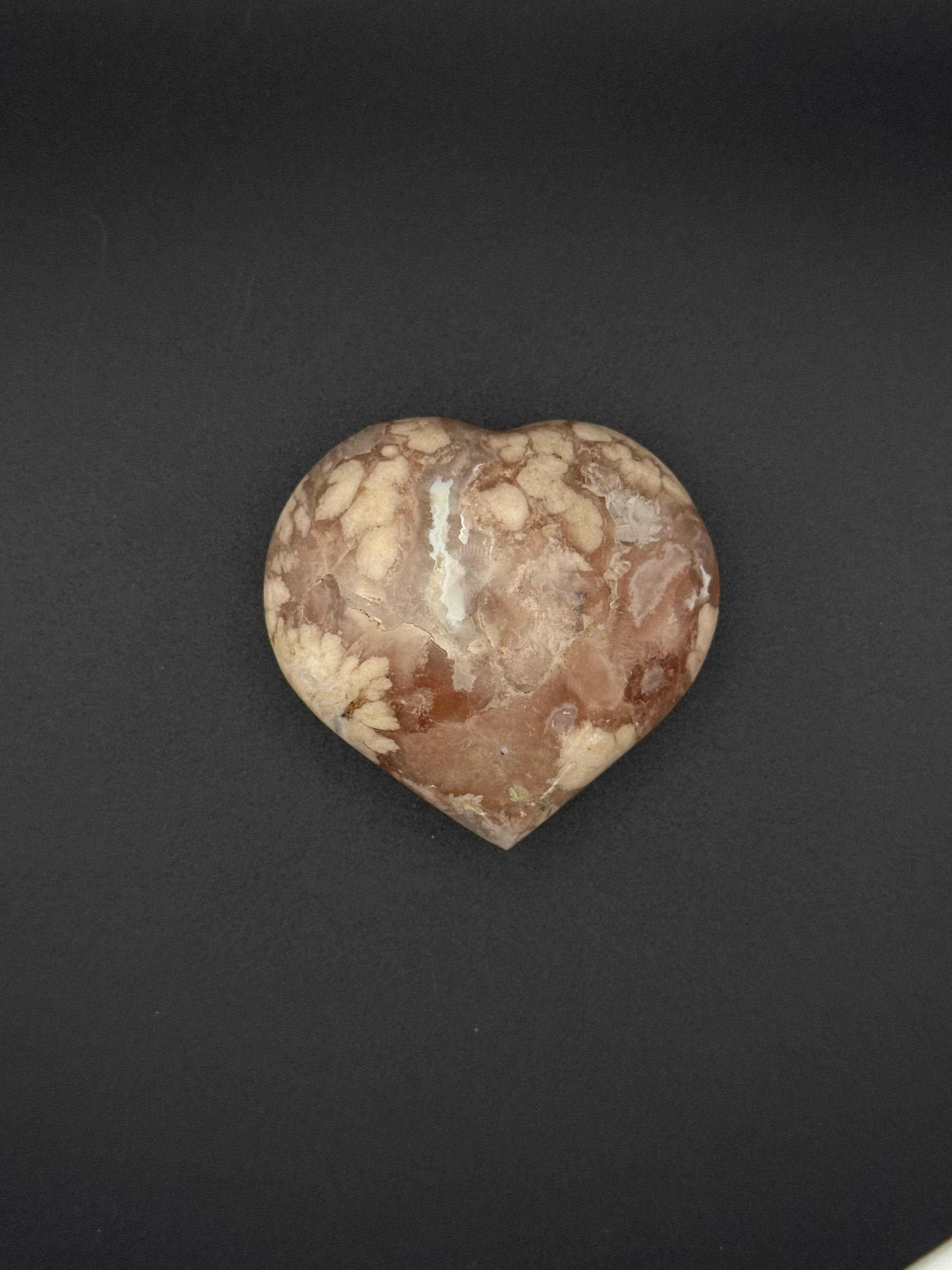 Flower agate polished crystal in the shape of a heart.