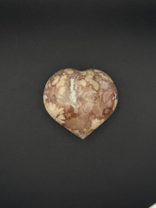 Flower agate polished crystal in the shape of a heart.