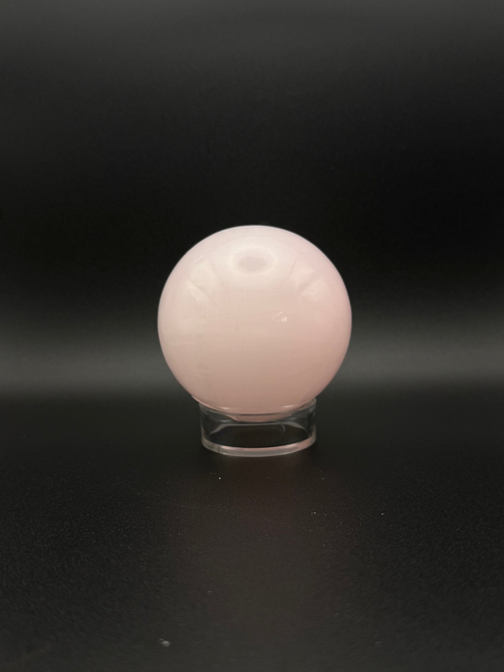 Polished pink calcite sphere. Pink calcite glows under uv light.