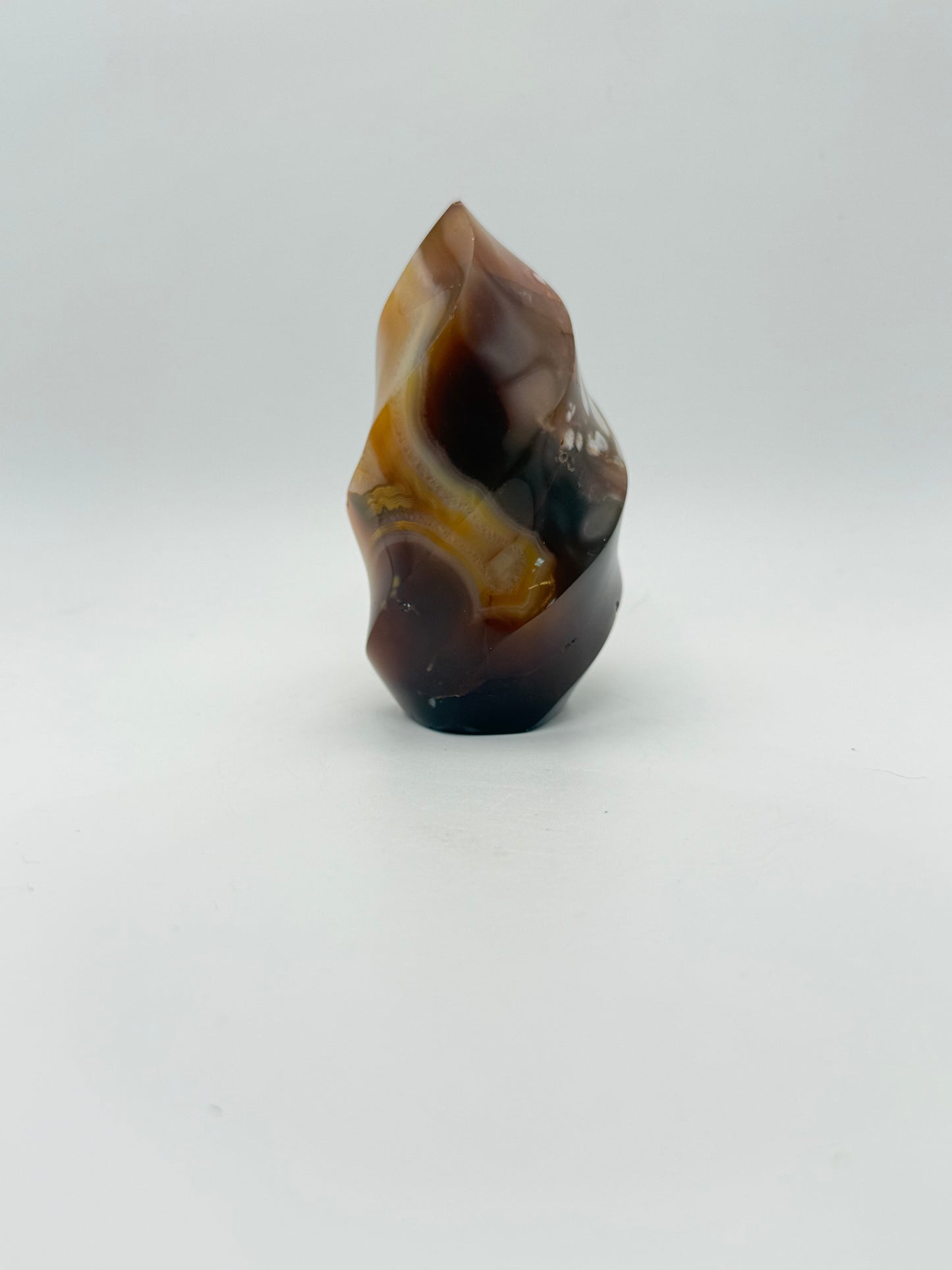 A polished carnelian stone with a flame shape, featuring an orange to red gradient color.