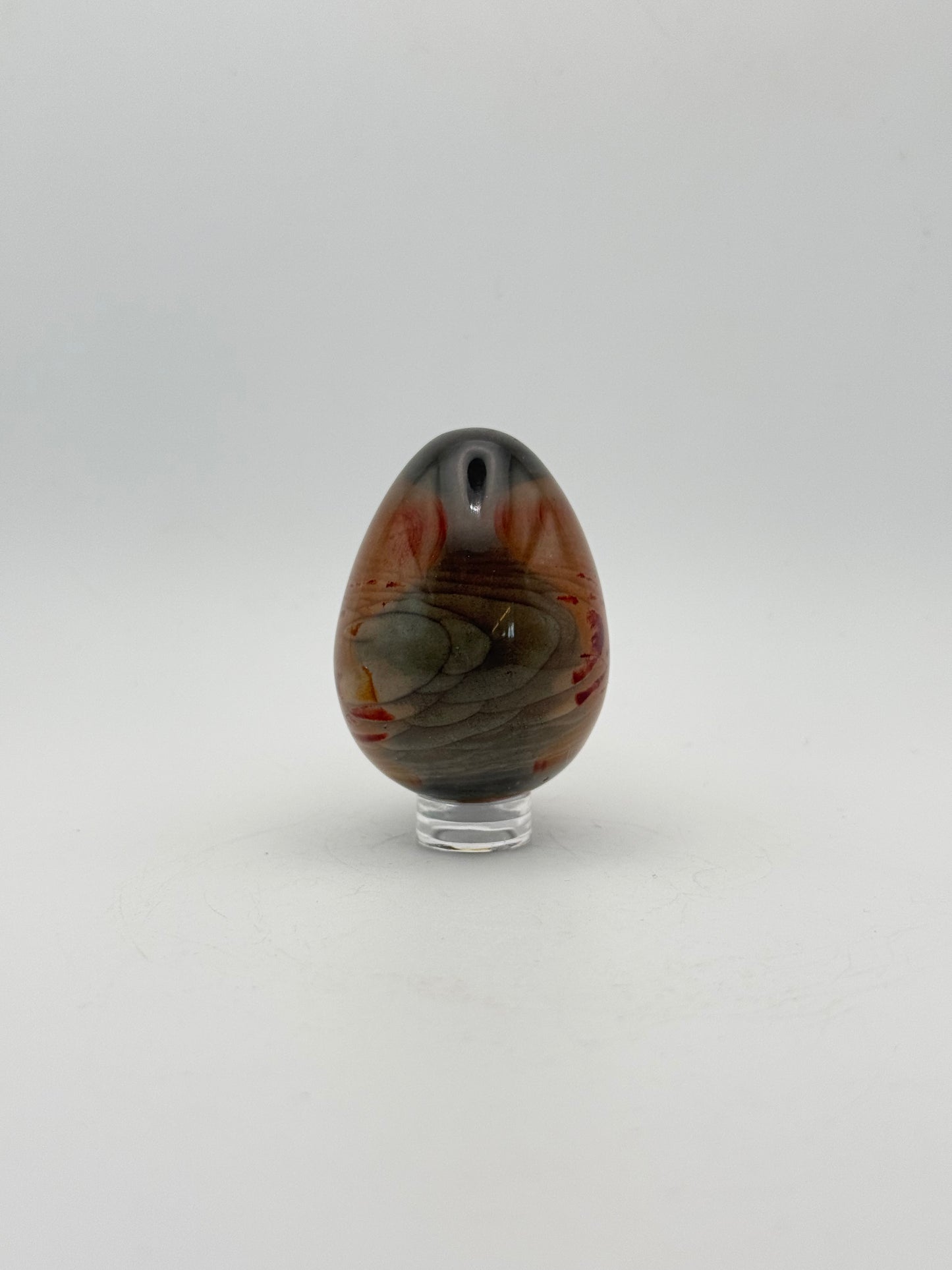 Polished polychrome jasper shaped into an egg.