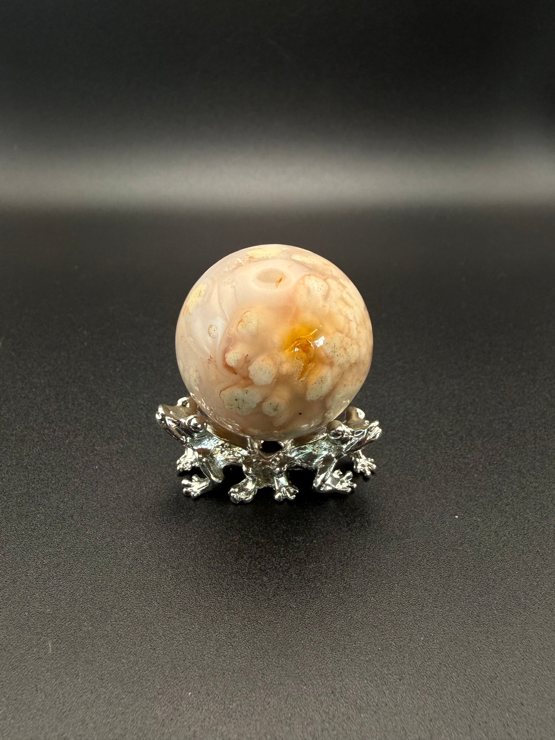 Flower agate polished crystal in the shape of a sphere.