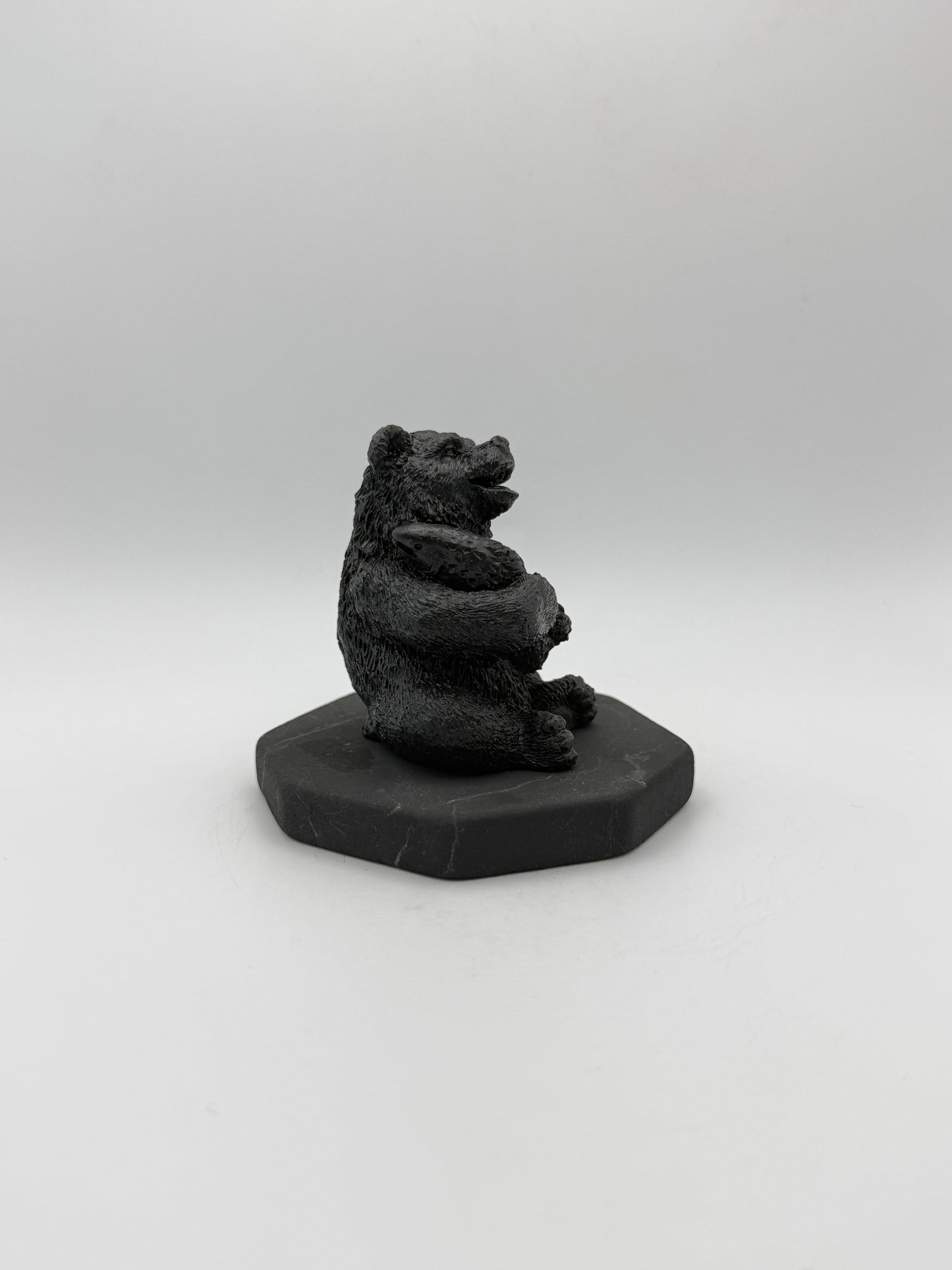 Shungite carving of a bear holding a fish.