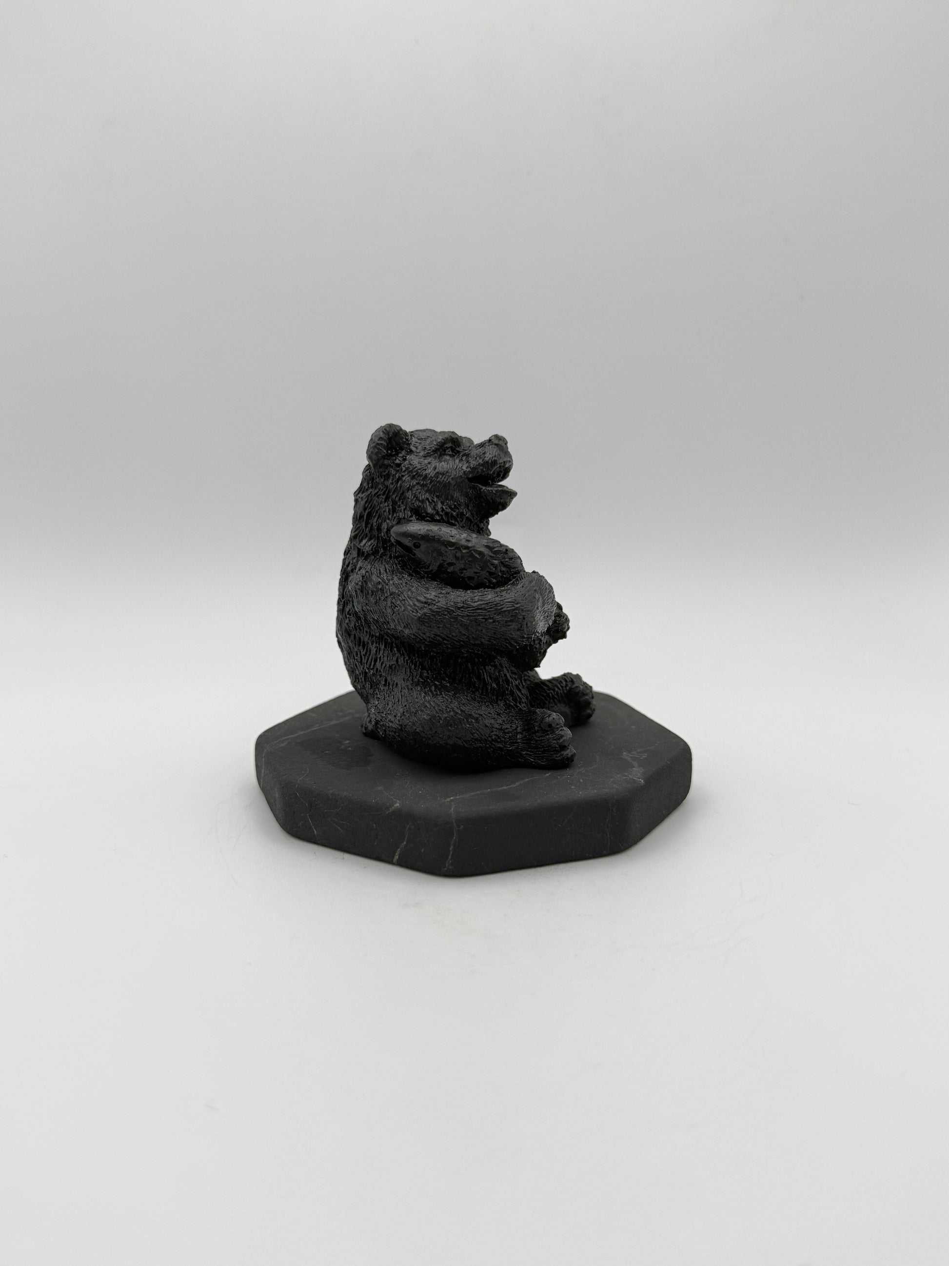 Shungite carving of a bear holding a fish.