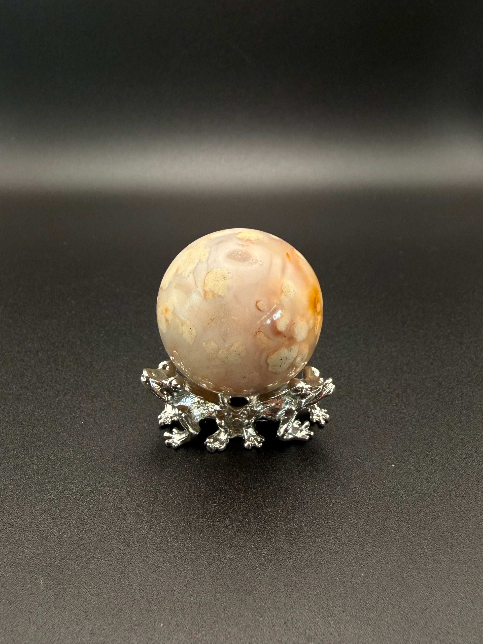 Flower agate polished crystal in the shape of a sphere.