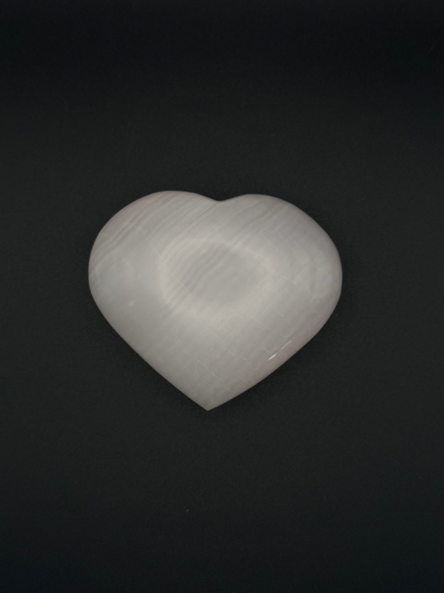 Polished pink calcite heart. Pink calcite glows under uv light.