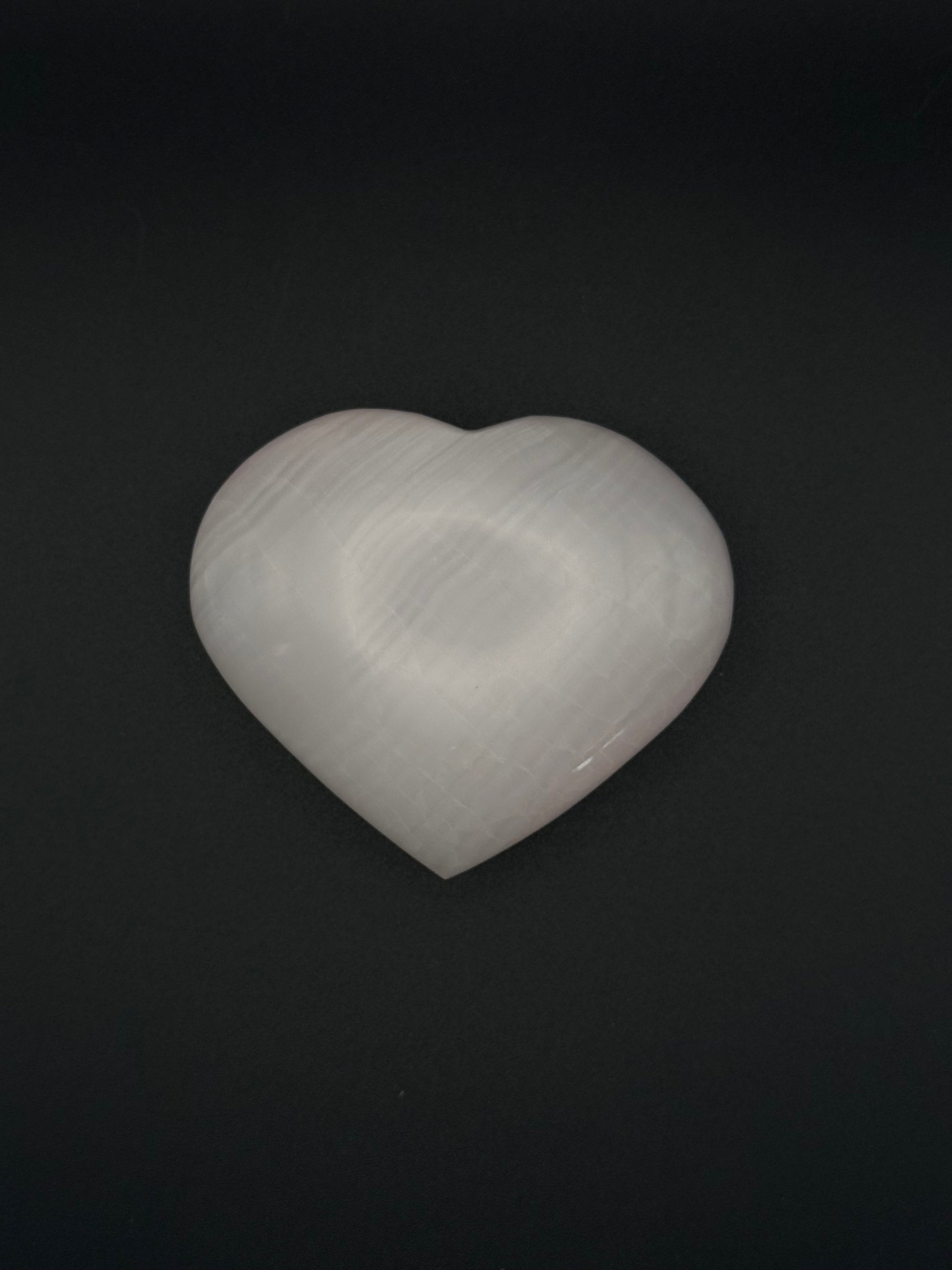Polished pink calcite heart. Pink calcite glows under uv light.
