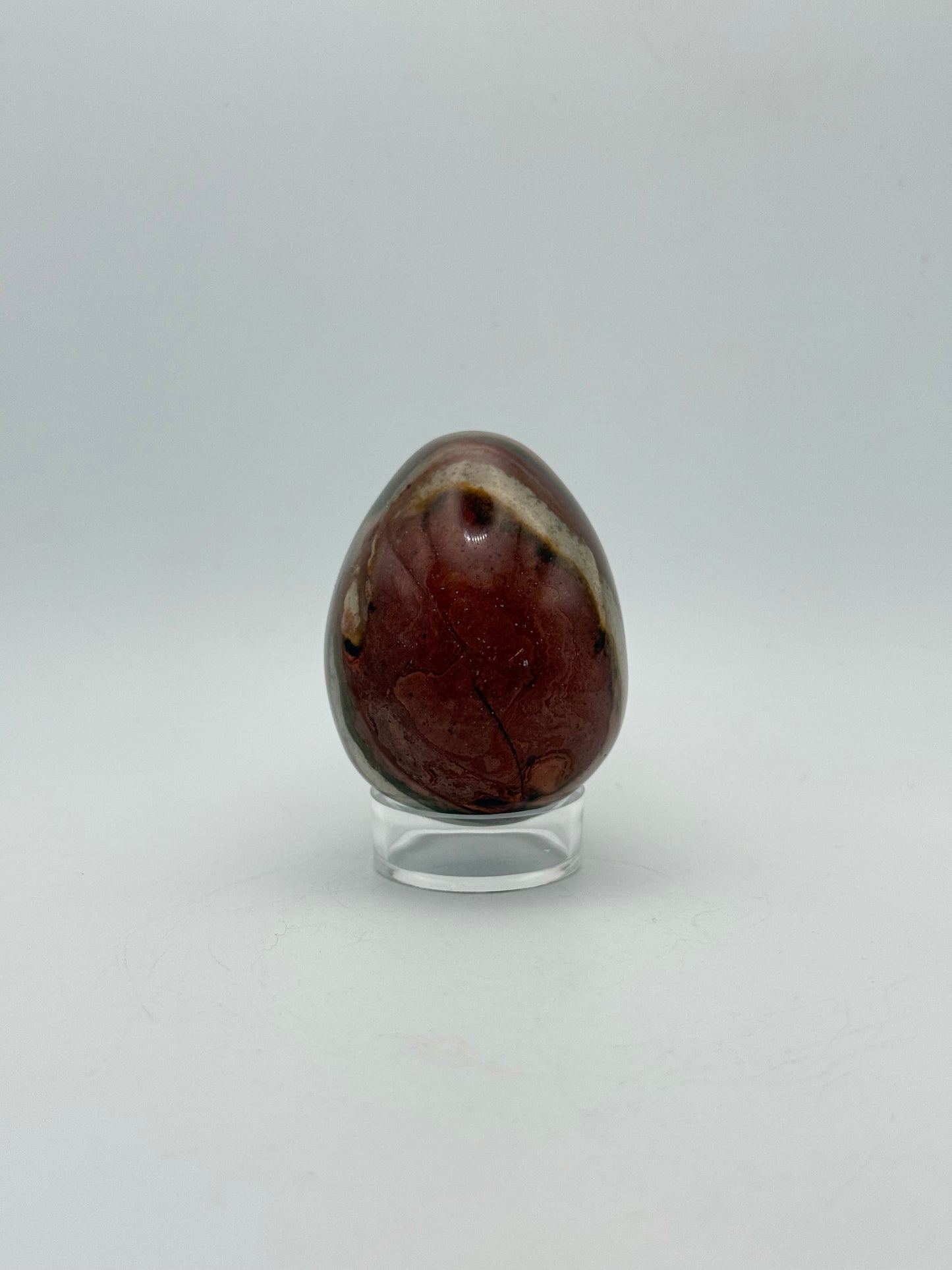 Polished polychrome jasper shaped into an egg.