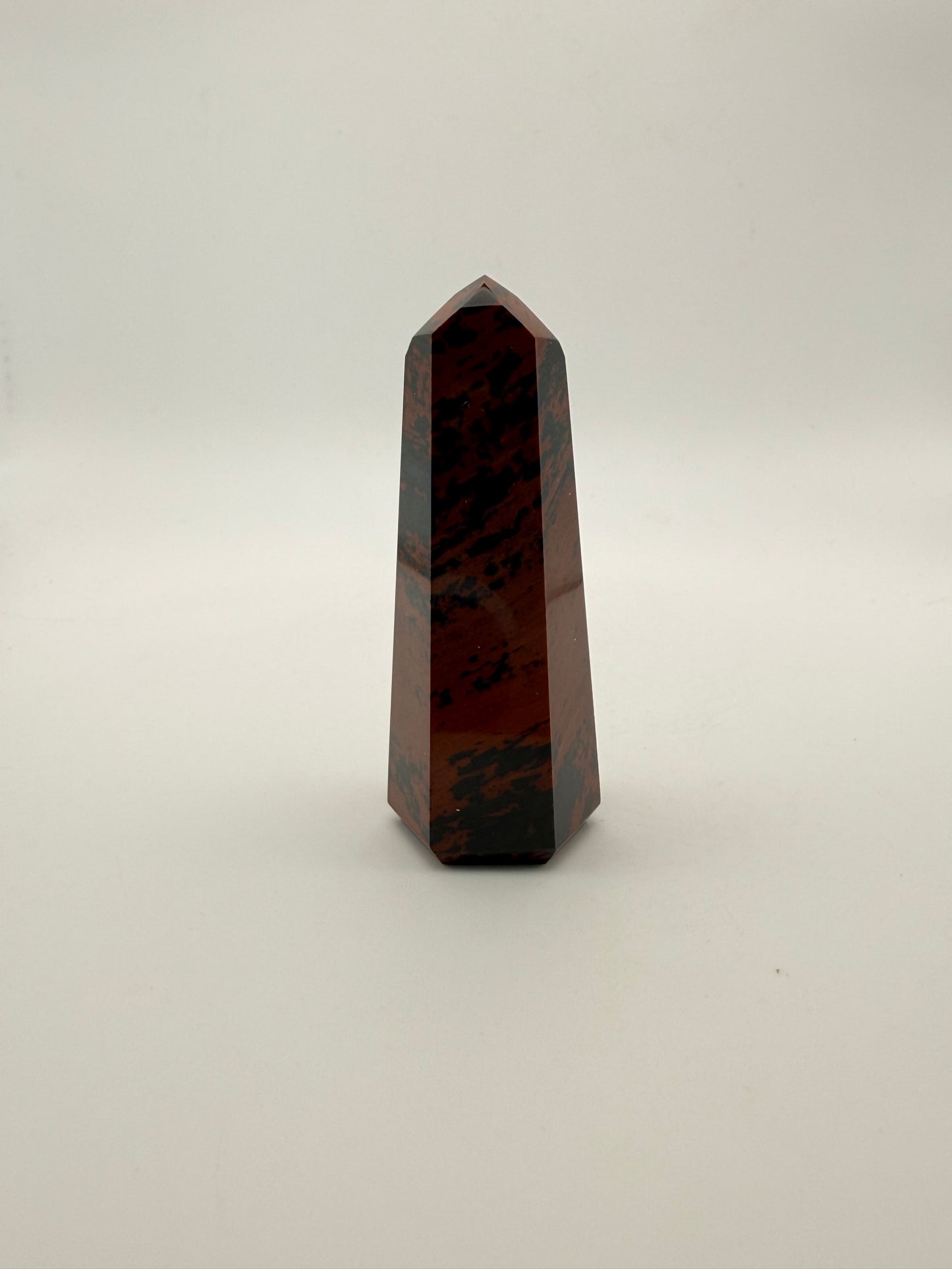 Polished mahogany obsidian tower with six sides.