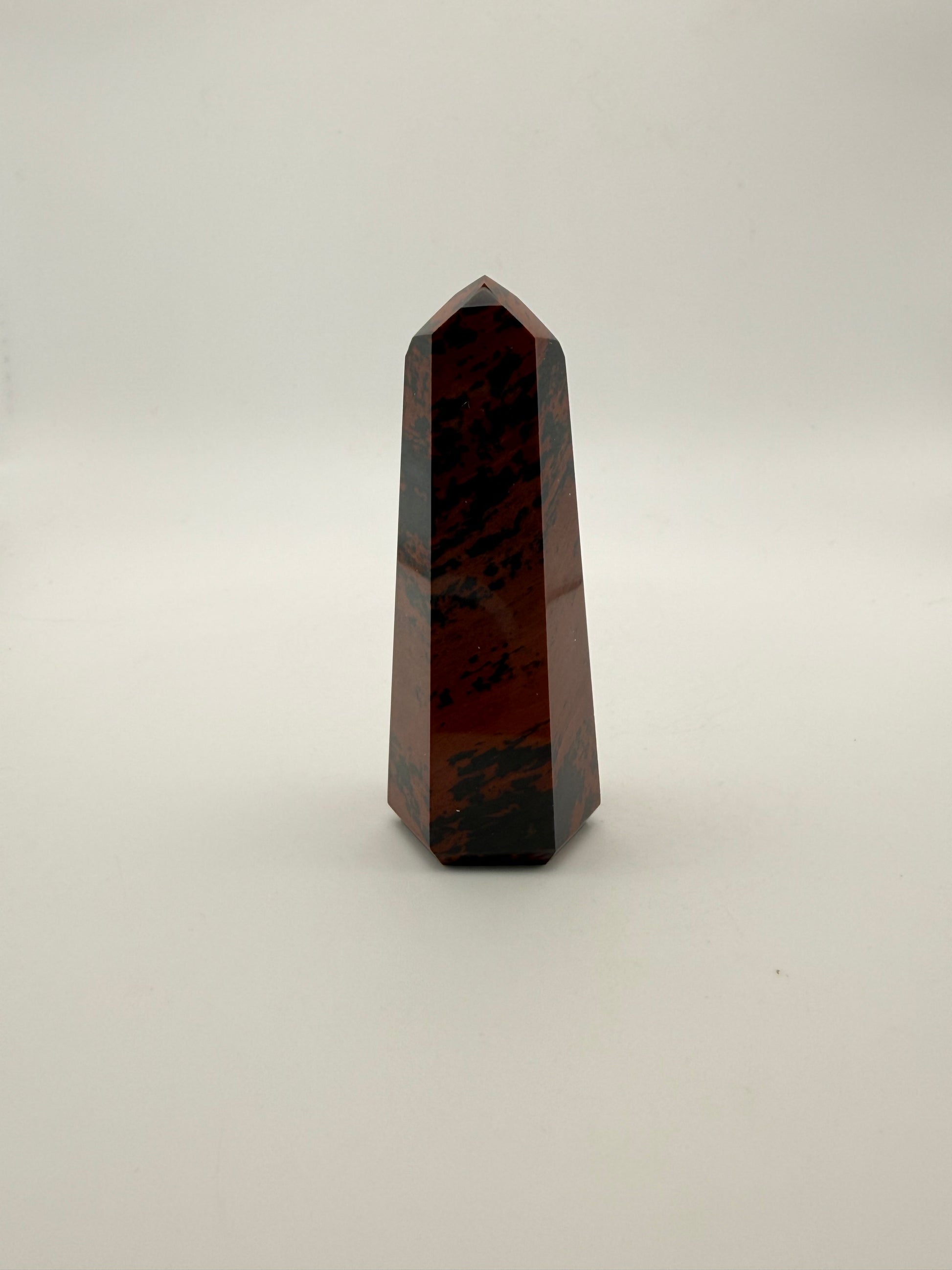 Polished mahogany obsidian tower with six sides.