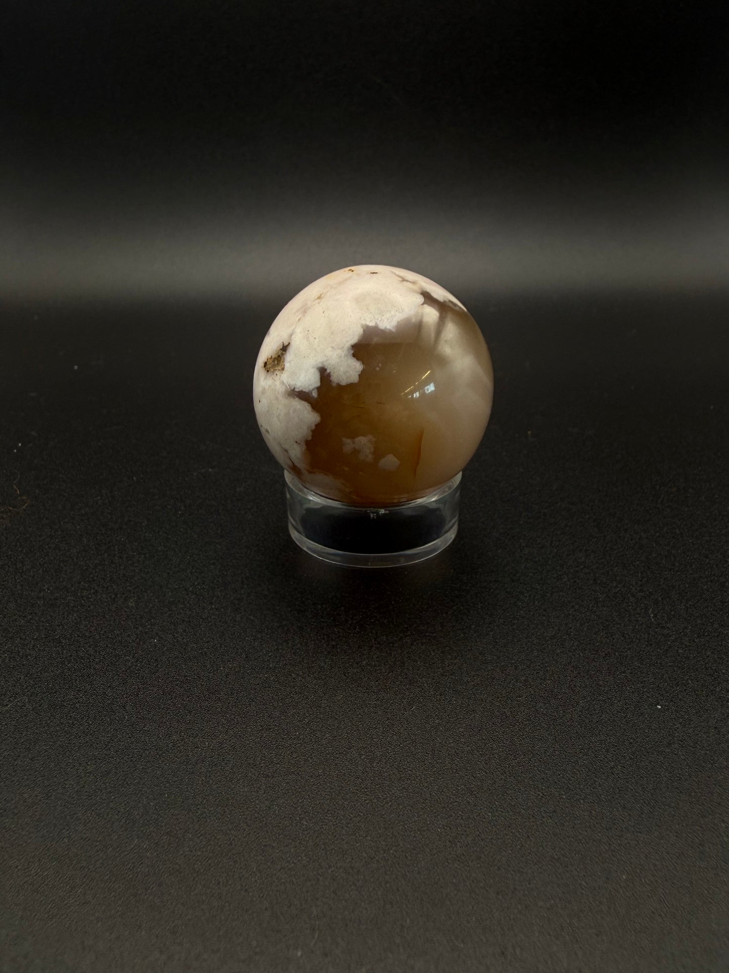 Flower agate polished crystal in the shape of a sphere.