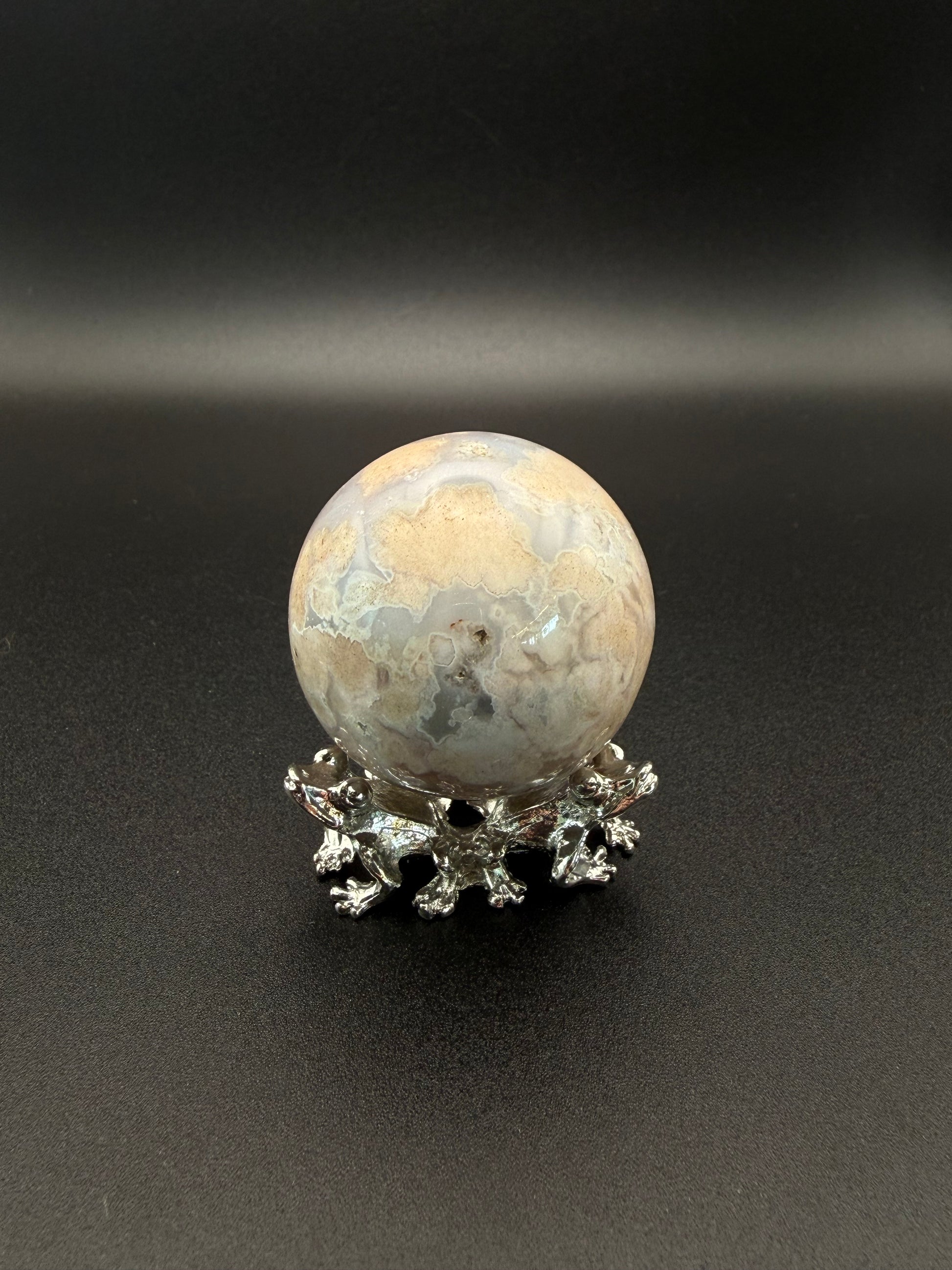Flower agate polished crystal in the shape of a sphere.