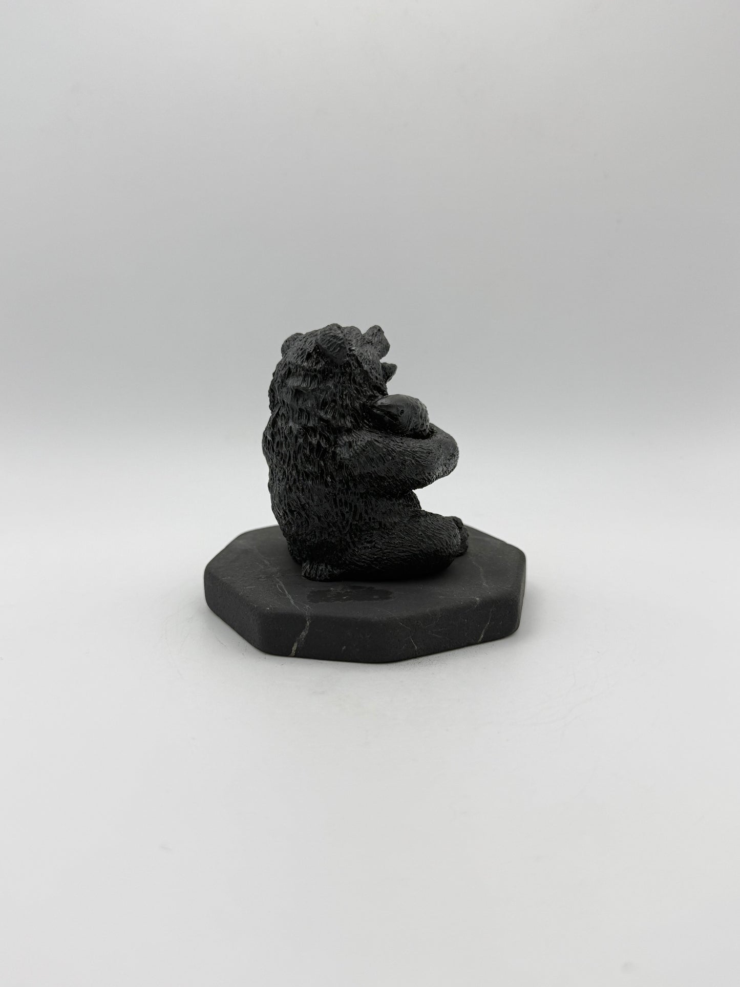 Shungite carving of a bear holding a fish.