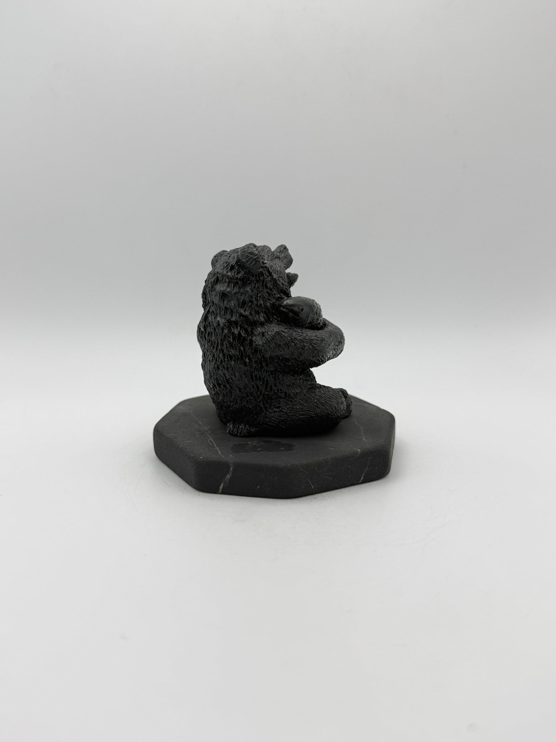 Shungite carving of a bear holding a fish.